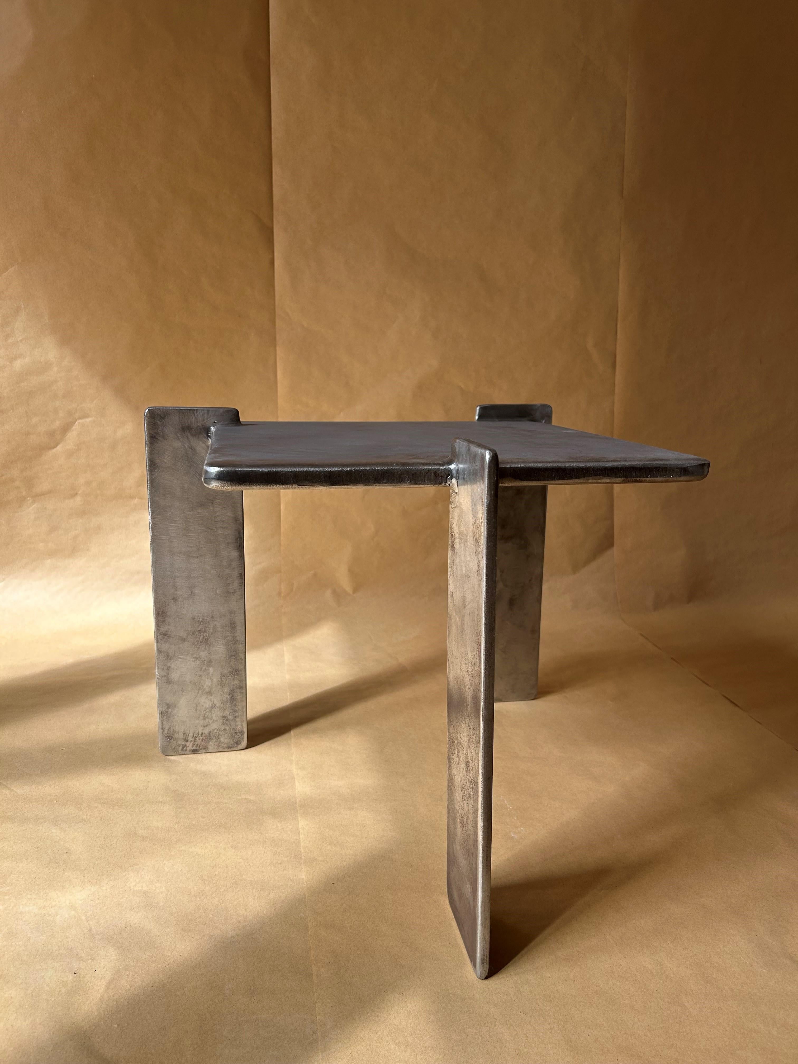 Tavolino in acciaio dal design minimalista creato dal designer/artigiano belga Oscar Santens. Le tre gambe conferiscono al pezzo un aspetto intrigante da ogni angolazione, dando vita al design. È senza tempo nella sua semplicità, un equilibrio