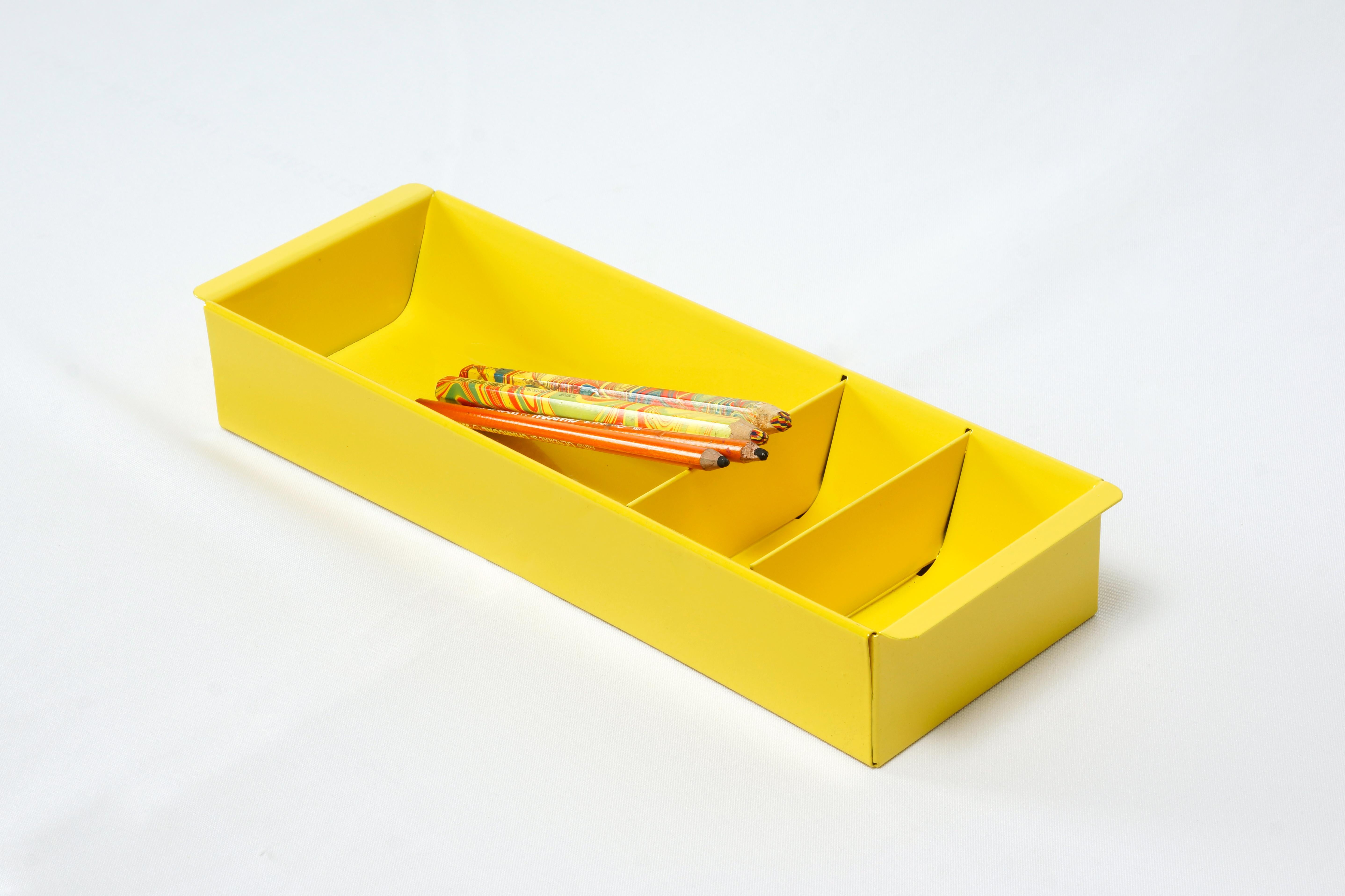 Once the insert to a classic tanker desk's utility drawer, we repurposed this neat Industrial piece for use as a desktop organizer. Steel has been newly powder-coated in a pop of Mellow Yellow (YL01). Features three slots, ideal for storing coins,