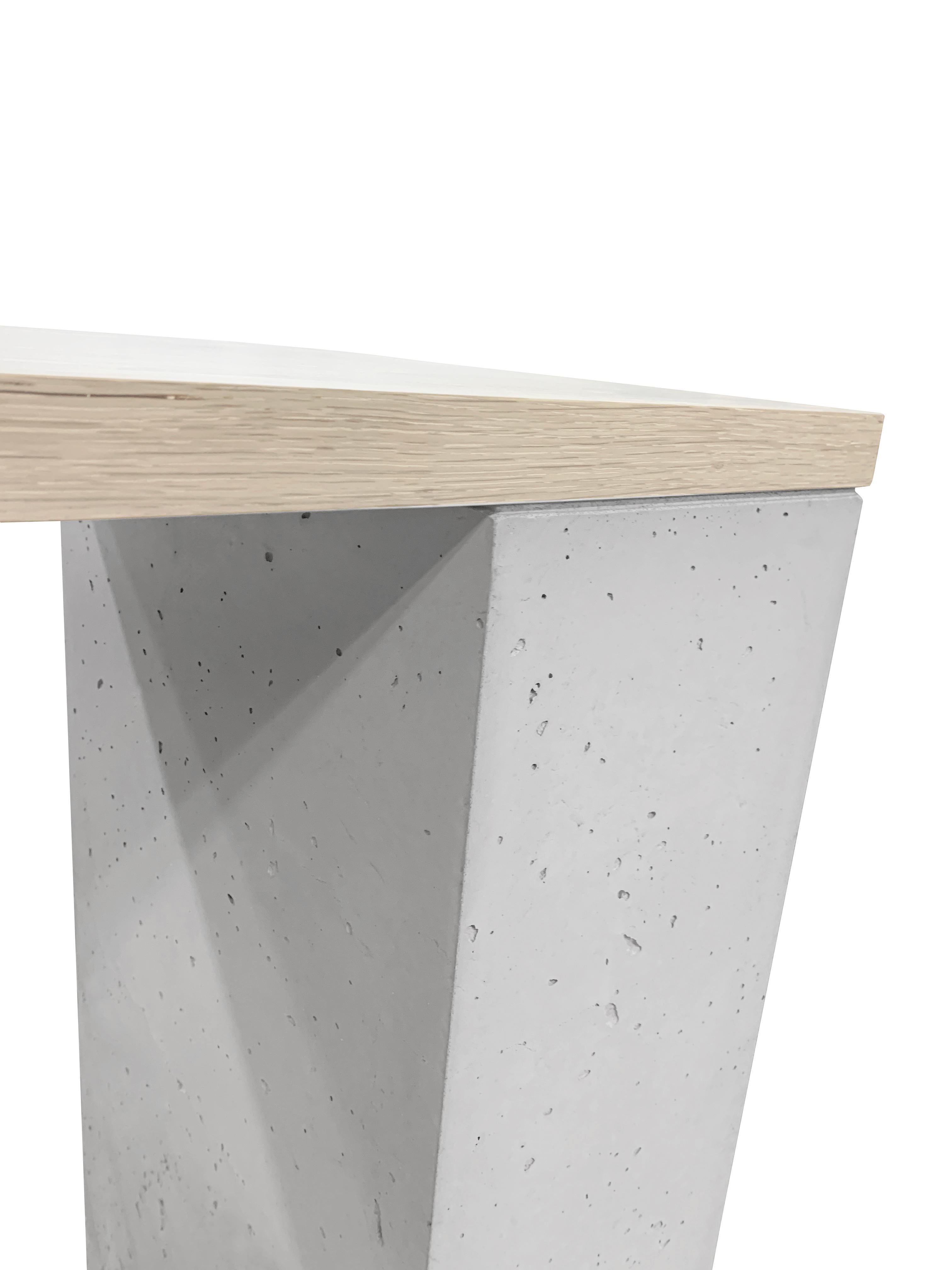 A blackened steel leg with a thru-tenon detail contrasts a bleached and white stained solid White Oak top with cast-concrete leg.

This is a bespoke piece so custom dimensions, materials, colors and finishes (both interior and exterior) can be