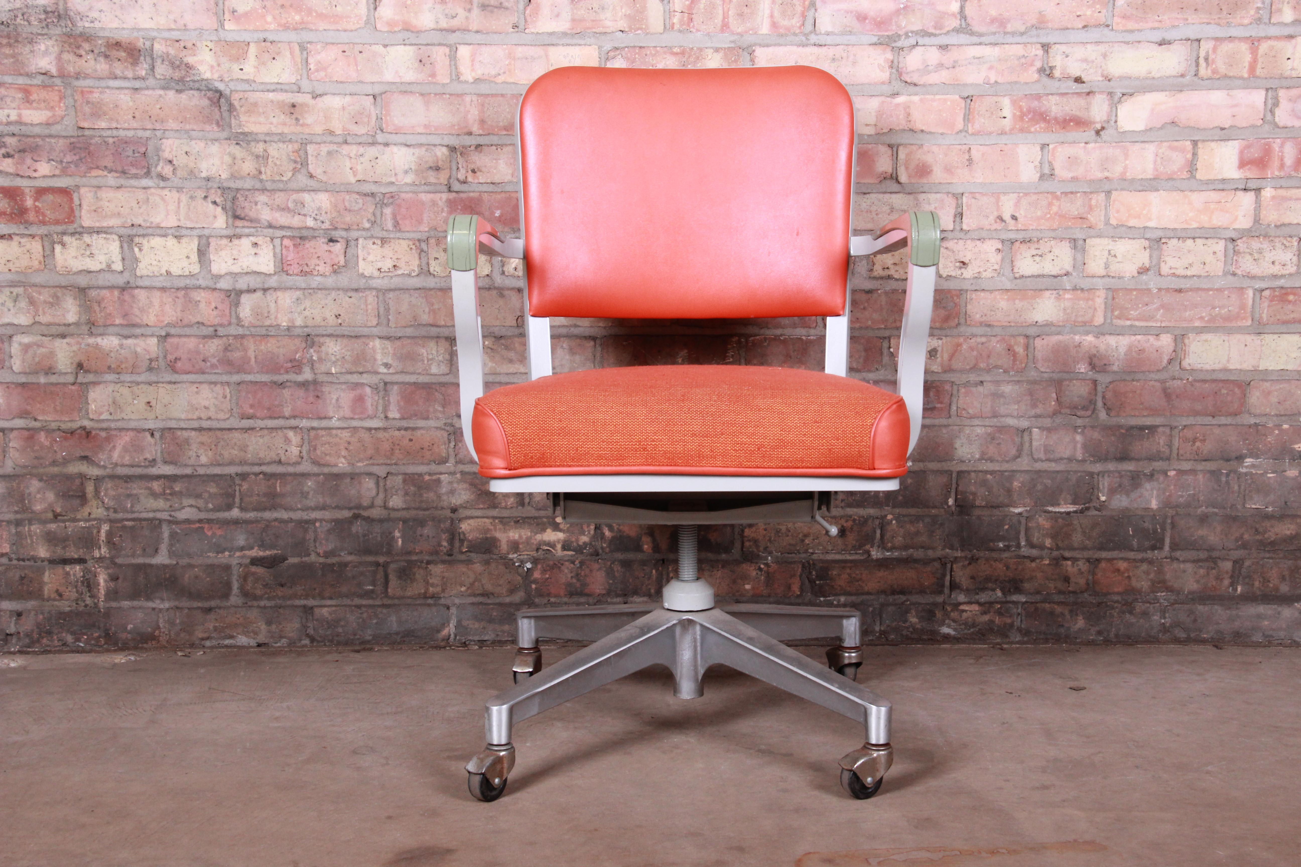 A very nice Mid-Century Modern office desk chair

By Steelcase

USA, 1963

Aluminum frame, with orange vinyl and fabric upholstery.

Measures: 23