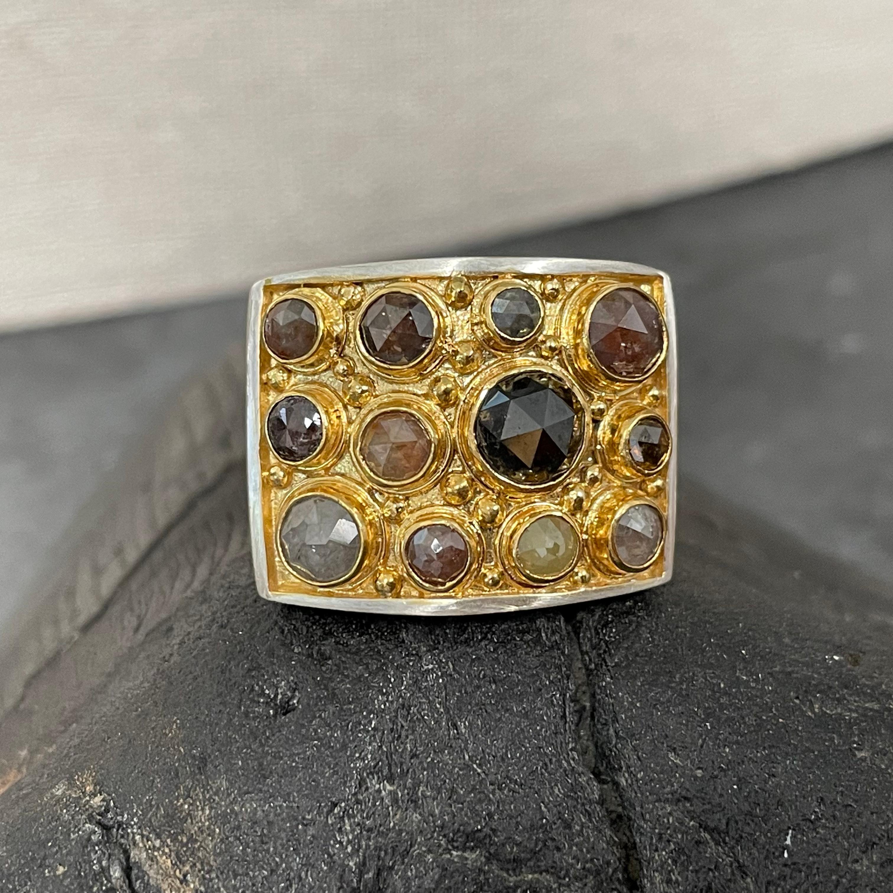 Twelve round rose-cut naturally colored diamonds of varying hues and sizes are set in bezels surrounded by double bezels and granulation interspersed atop a wide 