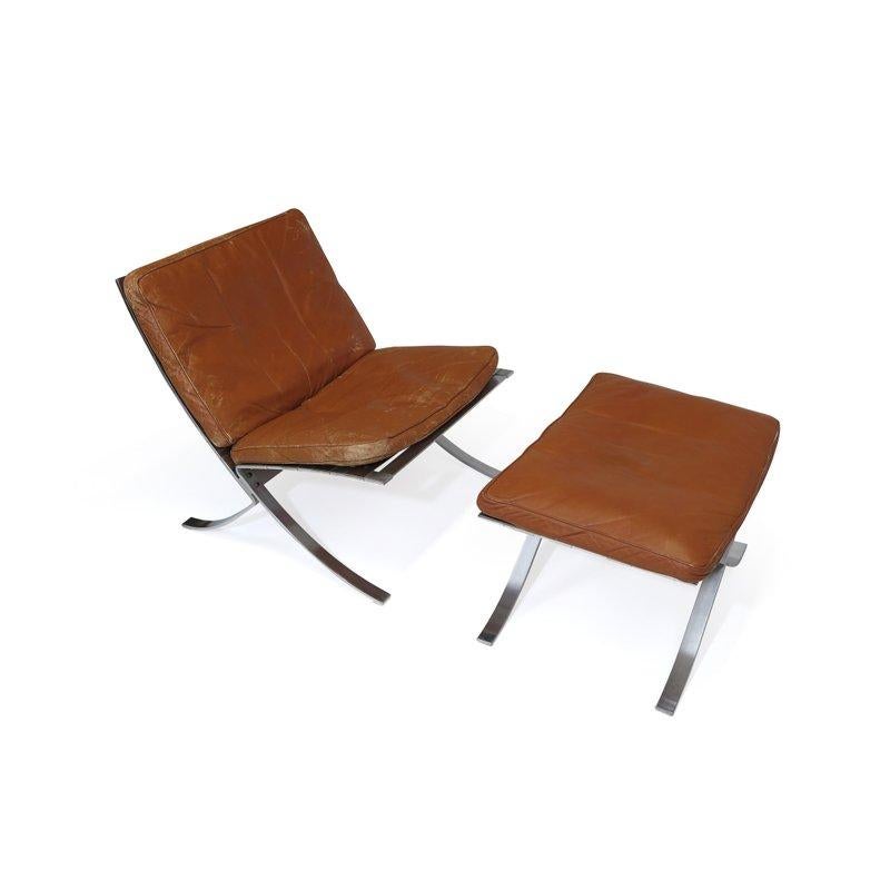 Steen Ostergaard steel frame lounge chair with original patinated leather cushions filled with down and rare foot stool.