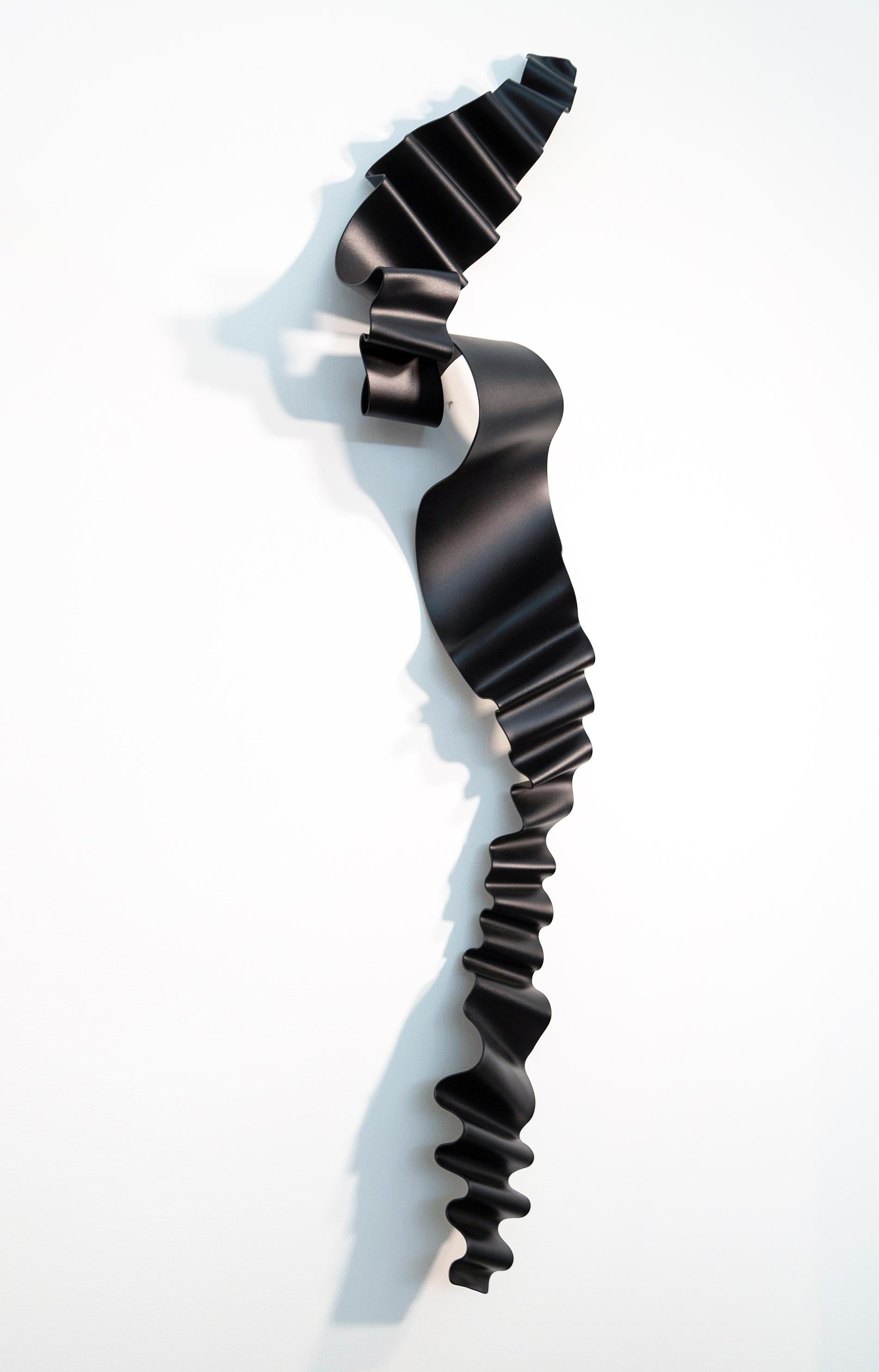 This dramatic wall sculpture as elegant and expressive as a cursive signature was created by Stefan Duerst. The German born artist’s ethereal work hand forges steel into dynamic compositions. This piece…a single ribbon of steel is powder coated in a