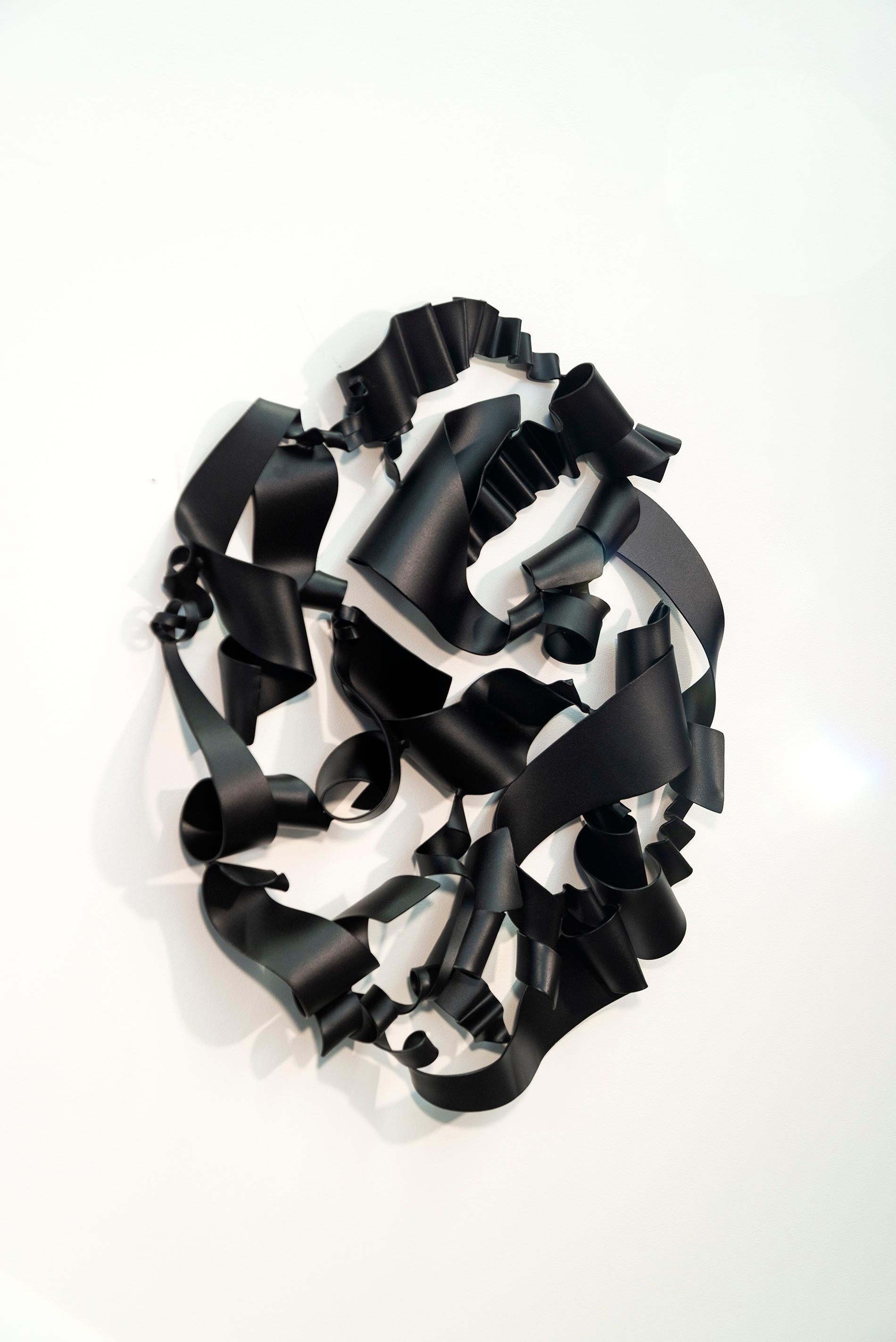 In elegant black, this expressive abstract wall sculpture was created by Stefan Duerst. The German born artist’s ethereal work hand forges steel into swirling ribbons that form dynamic compositions. The energy of this piece is accentuated by its