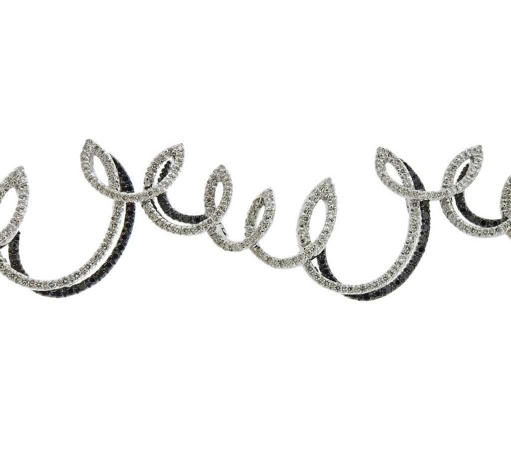 18k gold swirl motif bracelet by Stefan Hefner, set with a total of 3.01ctw in black and white VS diamonds. Bracelet is 6.5