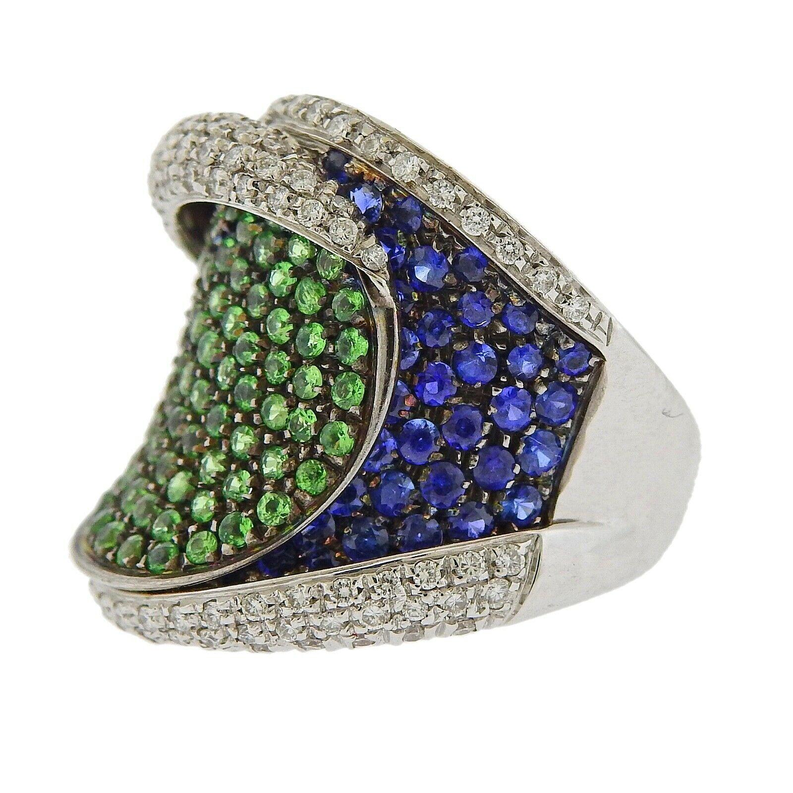 18k gold ring crafted by Stefan Hafner. Ring features 0.56ctw in VVS GH diamonds, and  green/blue sapphires. Ring size 6.5. Ring is 35mm at widest point. Total weight 14.2 grams. Marked SH, 750, Italian mark

