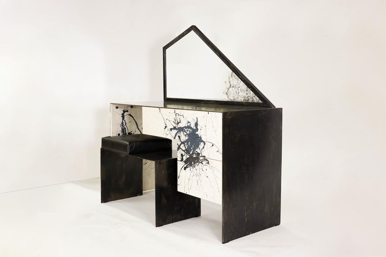 Stefan Rurak’s dynamic vanity/desk typifies his unique approach to design. The work features a heavily patinated steel and bleached ash desk, topped by a trapezoidal mirror that has been acid etched to mimic the expressionist painted decoration. The
