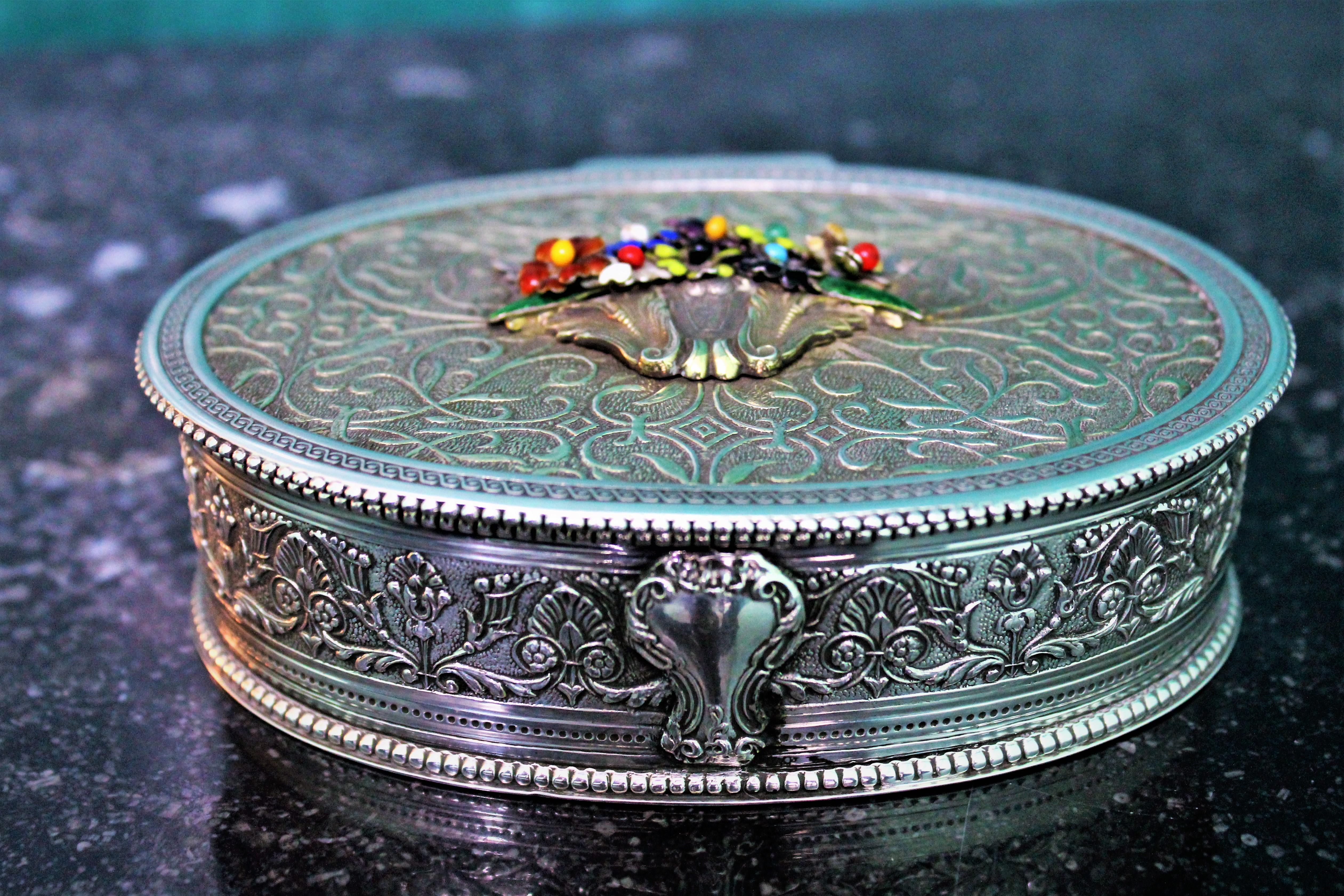 Wonderful decorative engraved silver box, realized by Enea Stefani, famous silversmith from Bologna during 1970s.
Oval shaped, engraved by hand and gilded in the inside. On the cover application of enameled silver flowers as finial.
Silver 800