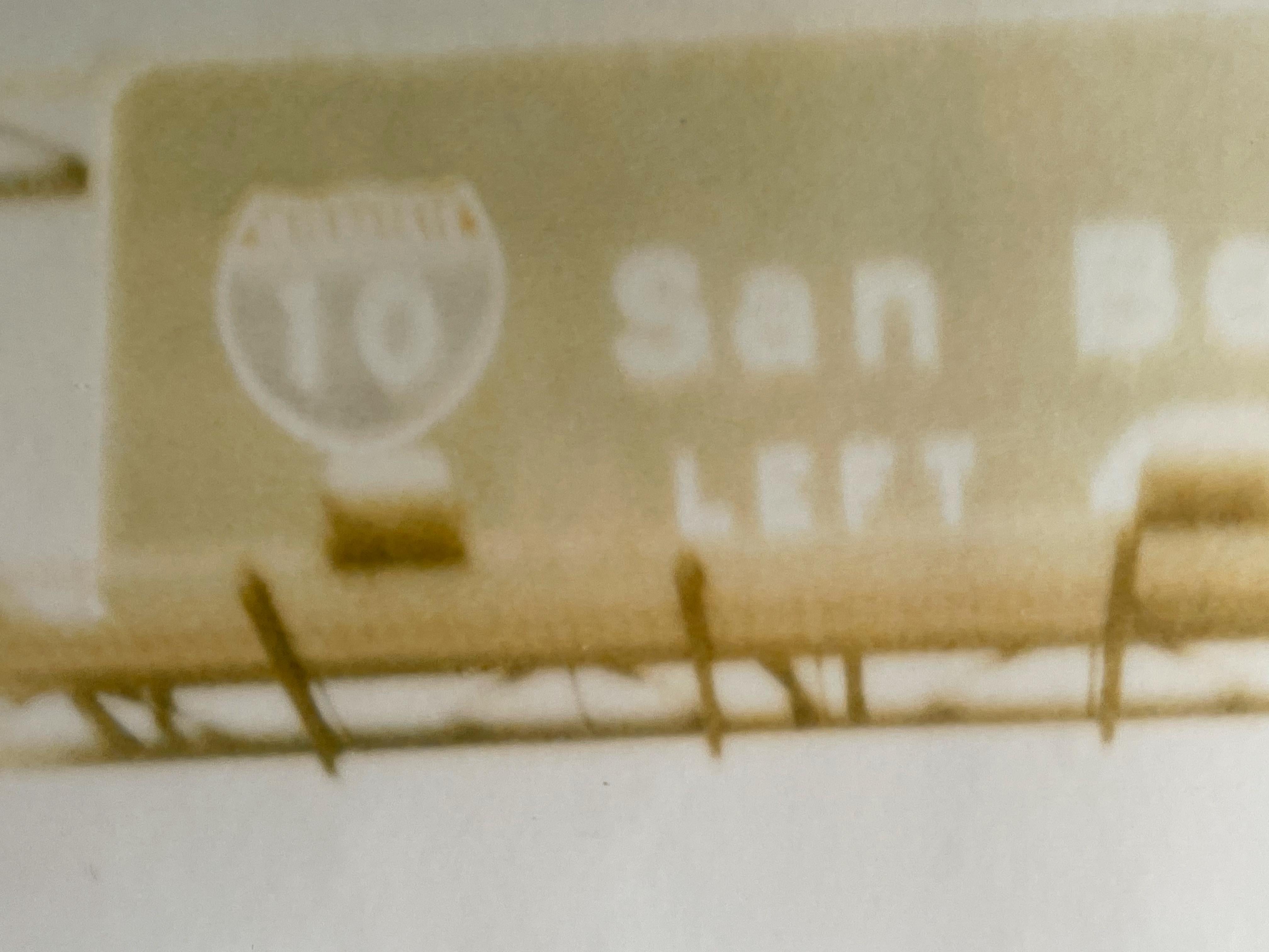 San Bernadino (Fahrt in die Wüste) - 1999

44x59cm, 
Auflage: 10 Exemplare plus 2 Probedrucke. 
Analoger C-Print, von der Künstlerin handgedruckt, basierend auf dem Original-Polaroid. 
Verso signiert mit Zertifikat. 
Künstler-Inventar #228. 
Nicht