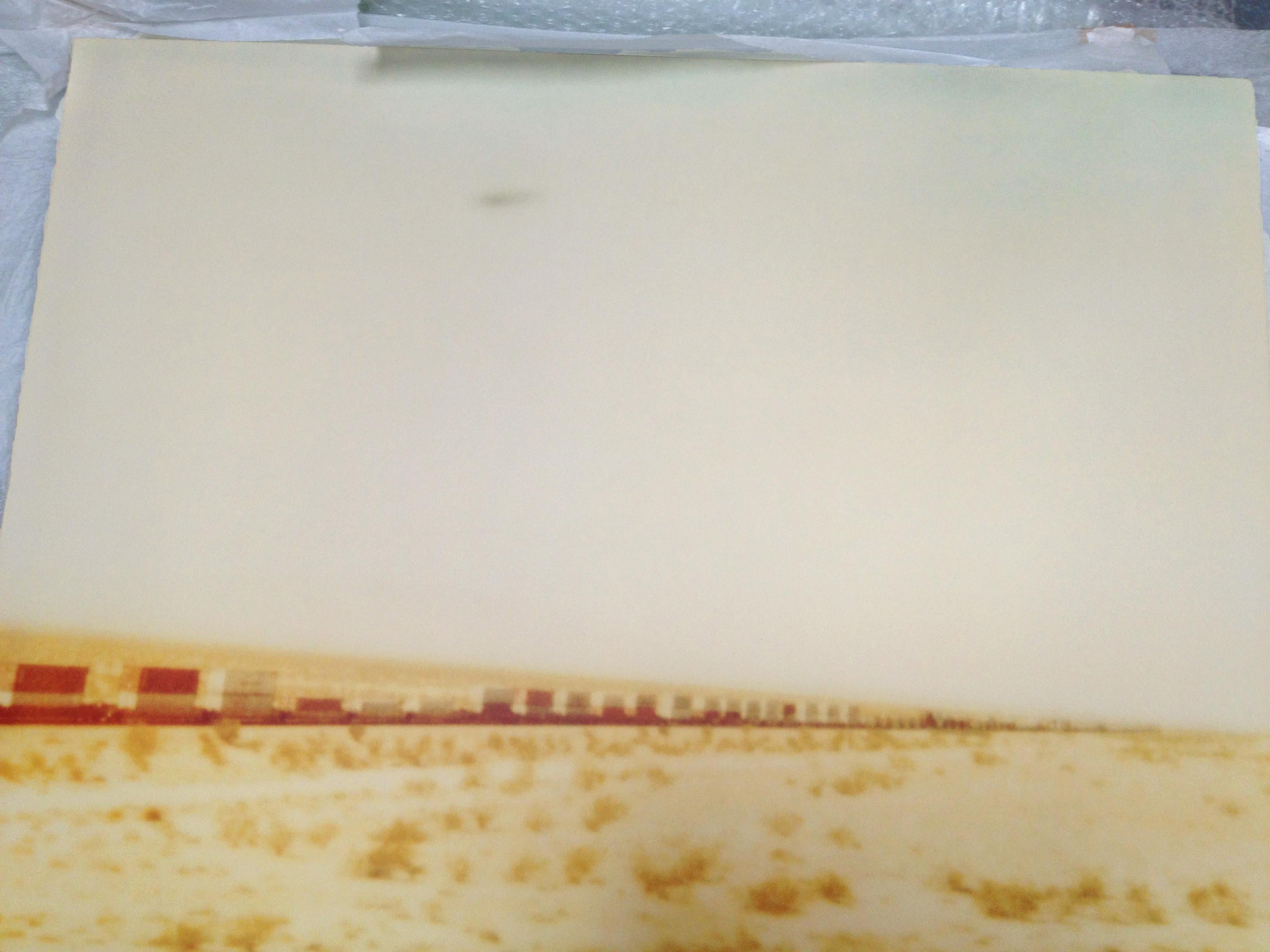 Train crosses Plain (Wastelands) - analog hand-print, mounted - Polaroid, Color - Contemporary Photograph by Stefanie Schneider