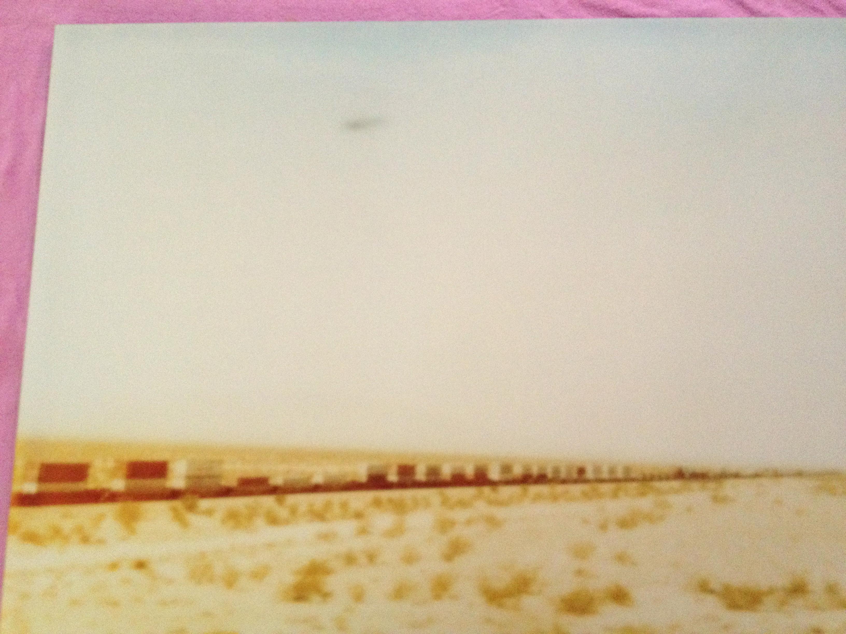 Train crosses Plain (Wastelands) - analog hand-print, mounted - Polaroid, Color - Beige Landscape Photograph by Stefanie Schneider