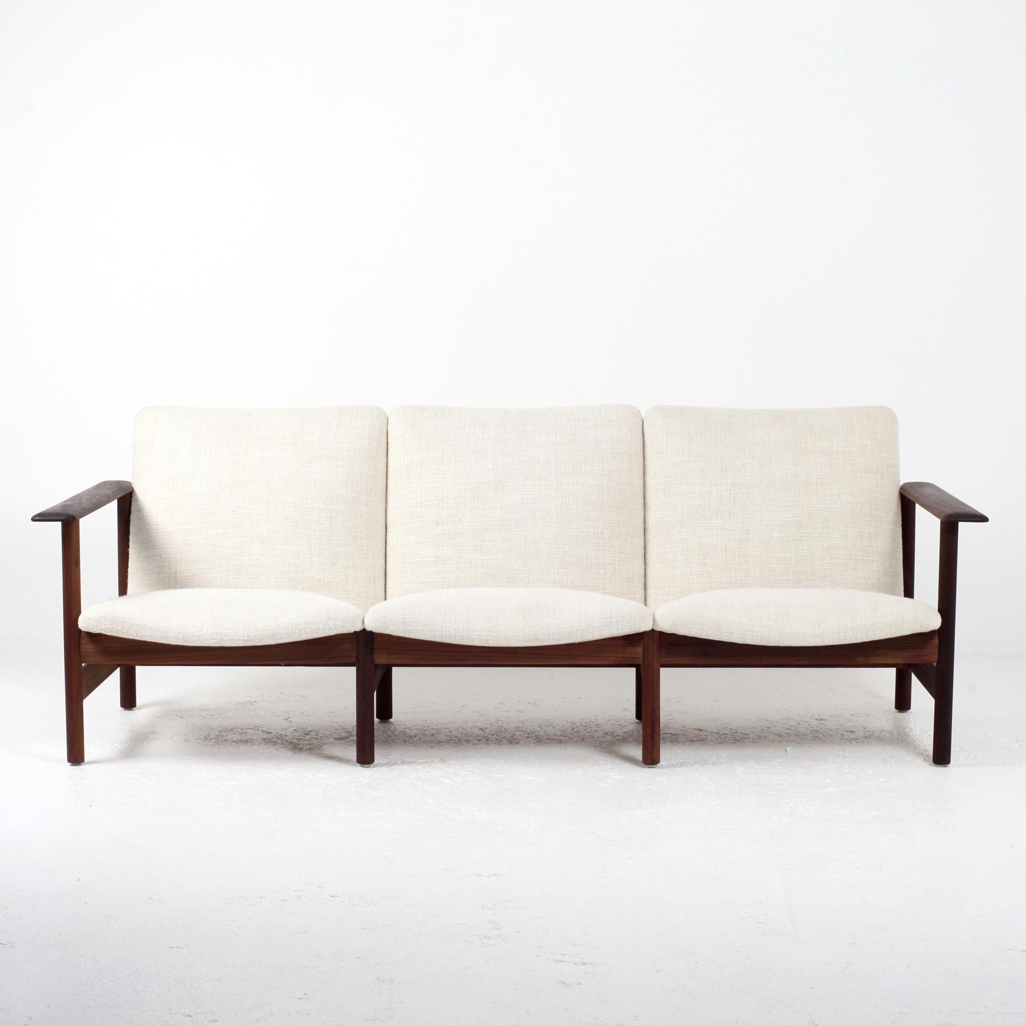 Un extraordinario sofá de mediados de siglo de los años 60 fabricado por Sièges Steiner. Con un armazón de madera maciza, el sofá ha sido retapizado profesionalmente en una nueva tela crema/beige muy suave de la casa Pierre Frey. Este moderno sofá