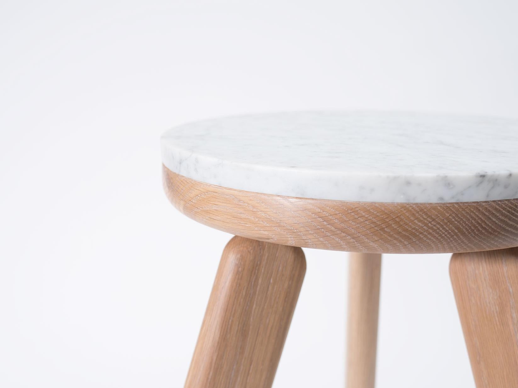 The Stele side table is handcrafted out of white oak and Carrara marble. Each table in the Stele series features a unique sculptural leg style. The Stele series utilizes and mix of stone and wood that compliments the properties of both materials;