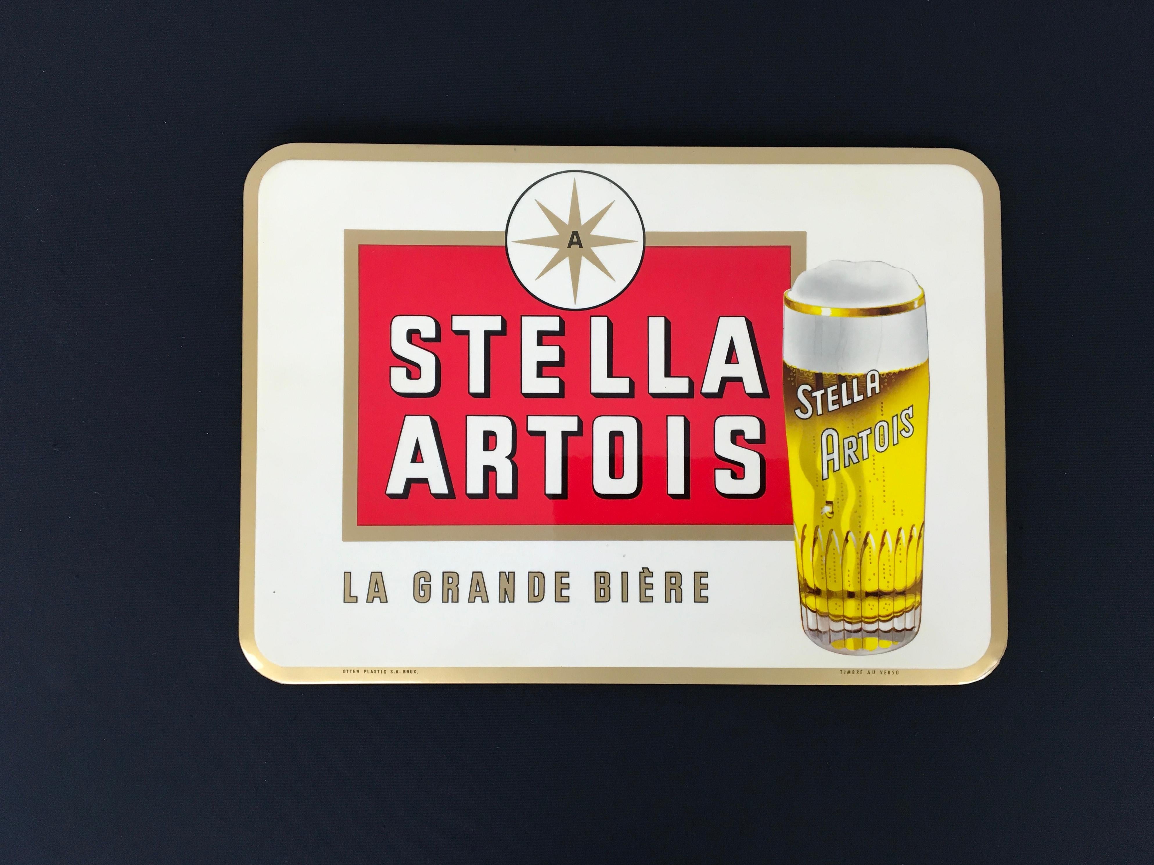 1960s Beer sign for the Belgian Beer Brand Stella Artois.
This Beer Sign was made by the Company Rob Otten which was located in Brussels. It's a glacoid sign mounted on cardboard. With original tax stamp at the back.

This vintage beer sign has a