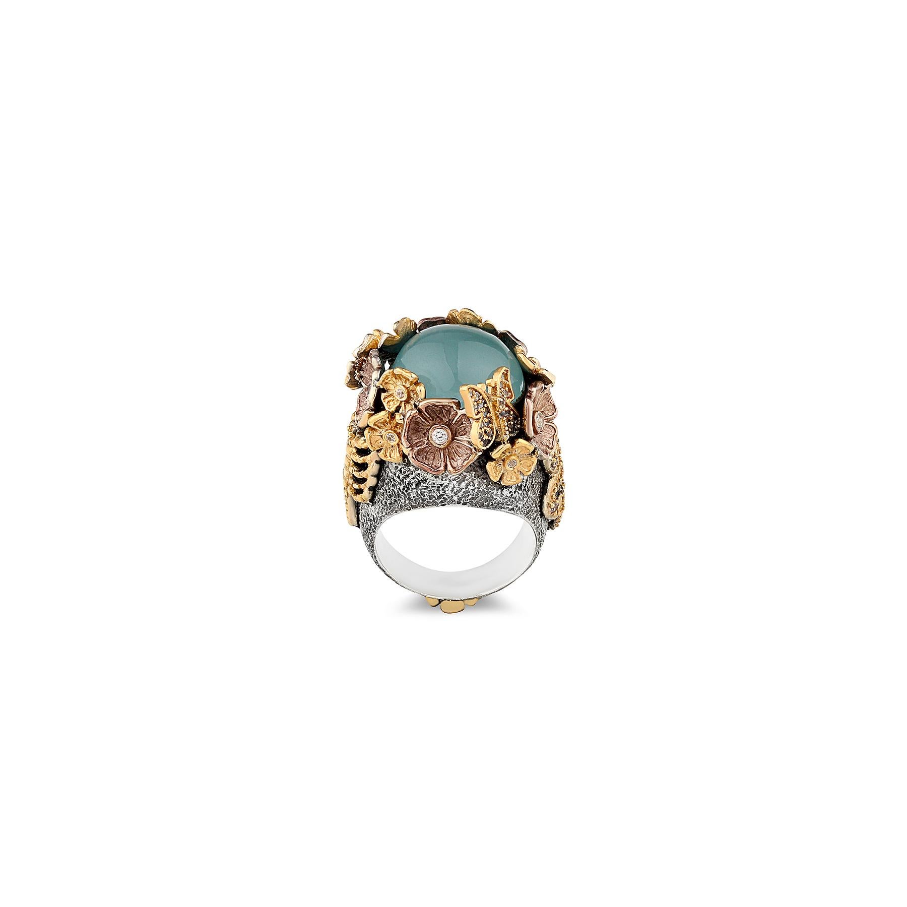 Cette magnifique bague de cocktail est créée avec un savoir-faire inégalé dans notre propre atelier par des maîtres joailliers pour les amoureux des bijoux floraux. Cette bague unique est ornée d'une aigue-marine cabochon de grande taille, entourée