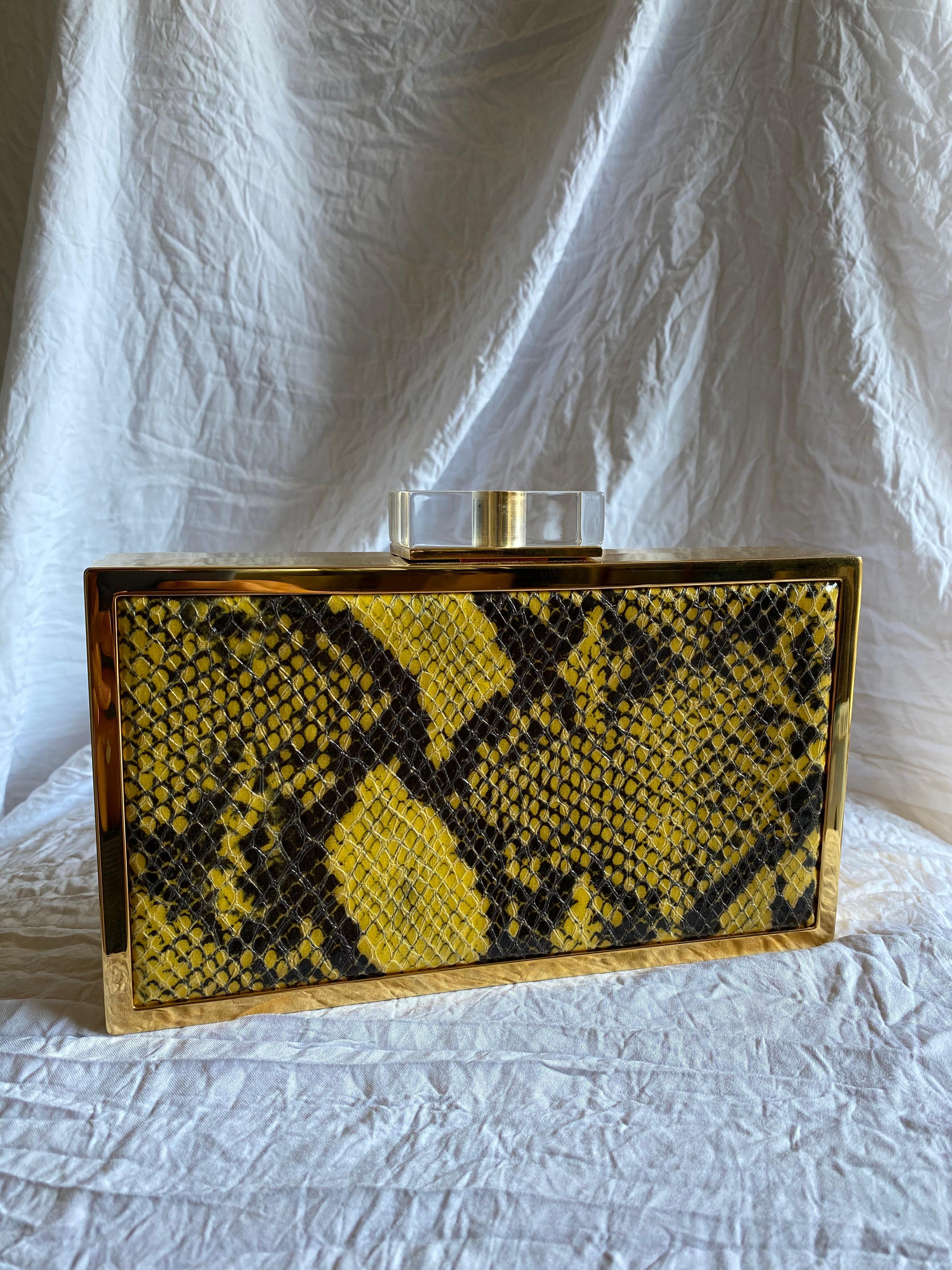 Stella McCartney’s vegan snake skin leather embossed and set into a reflective gold-tone frame with an optional chain. 

Condition: Good used condition. 
Exterior: Slightly uneven closure.
Interior: Lined with faux suede.
Made In: Italy
Serial