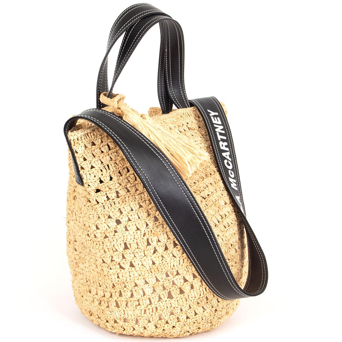 100% authentic Stella McCartney tote bag in crochet beige raffia with black faux-leather trim, handles and logo-embossed shoulder strap. Opens with a magnetic button on top. Unlined with one zipper pocket against the back and one open pocket against