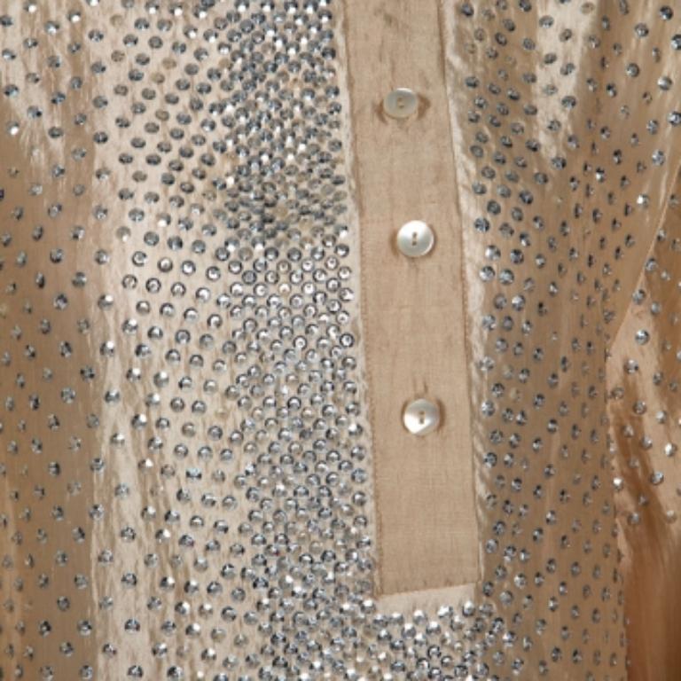 Questa splendida camicetta di Stella McCartney è un must-have. È realizzato in seta al 100% e si presenta in un'incantevole tonalità di beige. Ha una bella silhouette, maniche a palloncino, dettagli in paillettes e chiusura con bottoni. Il top può