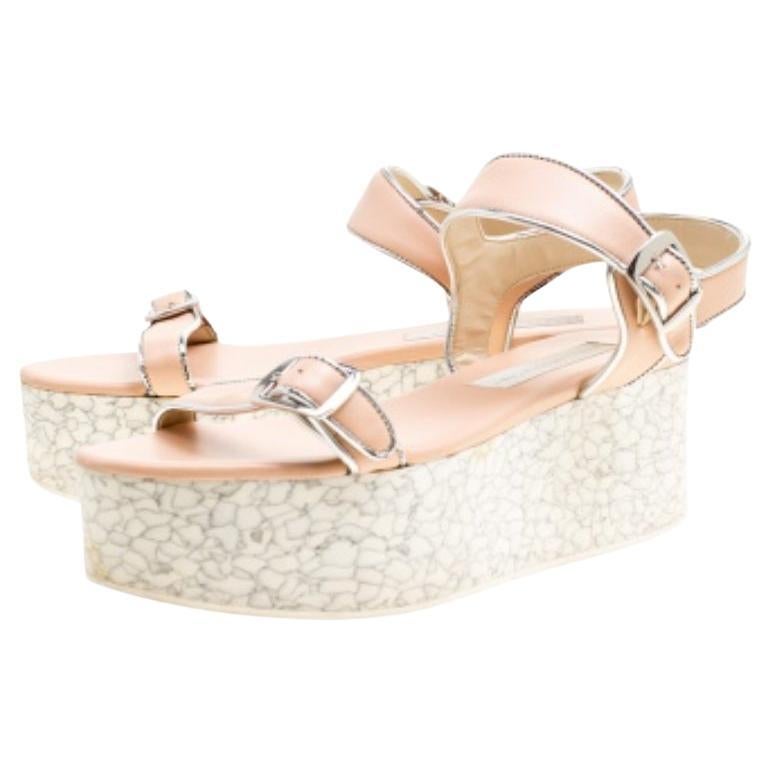 Très chics et élégantes, ces sandales Geena de Stella McCartney valent le coup ! Ces sandales beiges et argentées sont confectionnées en similicuir et présentent une silhouette à bout ouvert. Ils sont dotés d'une empeigne à boucle et d'une bride à
