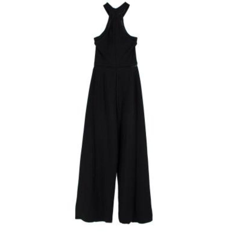 Stella McCartney Black Jumpsuit

-Concealed zip fastening along the back 
-Cut out details 
-Wide leg 
-Cross halter neck 

Material: 

83% Viscose 
17% Polyester 

Made in Italy 

PLEASE NOTE, THESE ITEMS ARE PRE-OWNED AND MAY SHOW SIGNS OF BEING