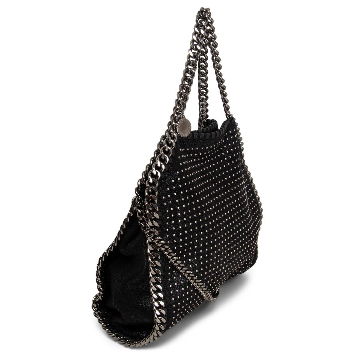 100% authentic Stella McCartney studded 'Falabella Mini' fold-over tote bag in black shaggy deer faux leather. Features the signature logo and a silver-tone hardware. Opens with a magnetic button and has a small interior pocket. Lined in pink logo