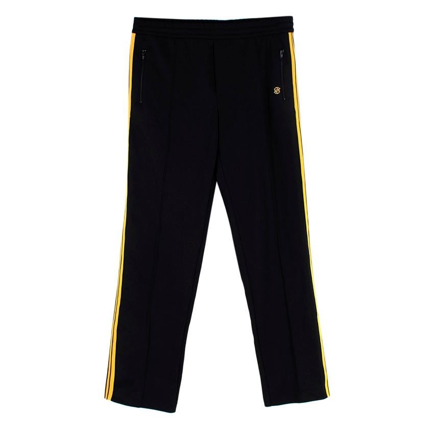 Stella McCartney Black Yellow Stripe Track Pants
 

 - Black tracksuit trousers with yellow side stripe detailing
 - Embroidered S logo to the front
 - Elasticated waistband
 - Two side slit pockets
 

 Materials 
 55% Polyester 
 45% Cotton 
