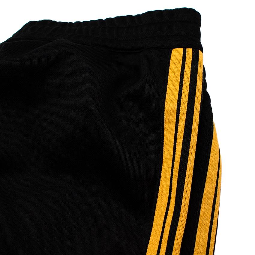 black track pants with yellow stripe