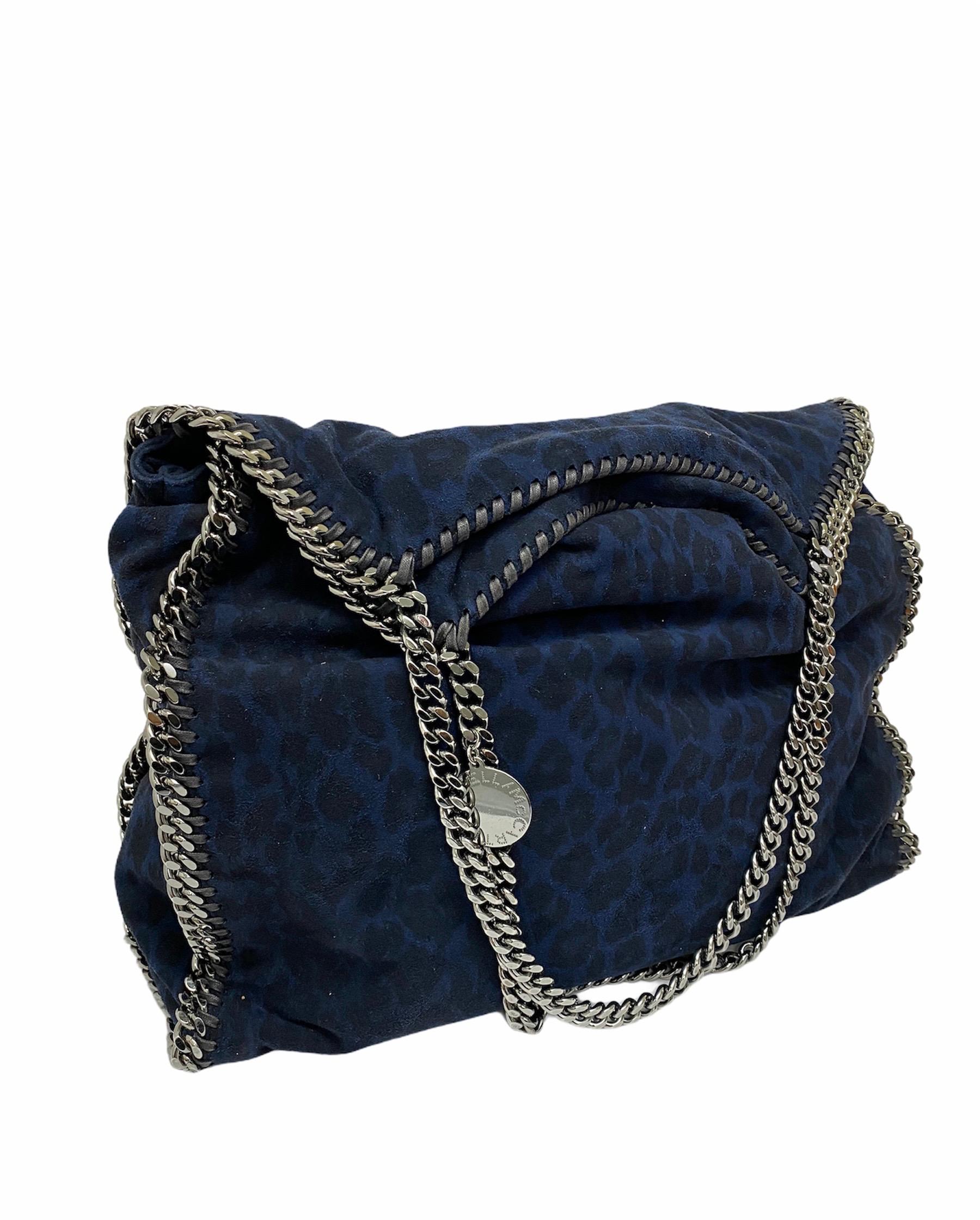Stella McCartney bag, Falabella model, made of spotted blue suede with silver hardware. The product has a button closure, internally lined in black fabric, very roomy. It is also equipped with two chain handles, an internal zip pocket, a cell phone