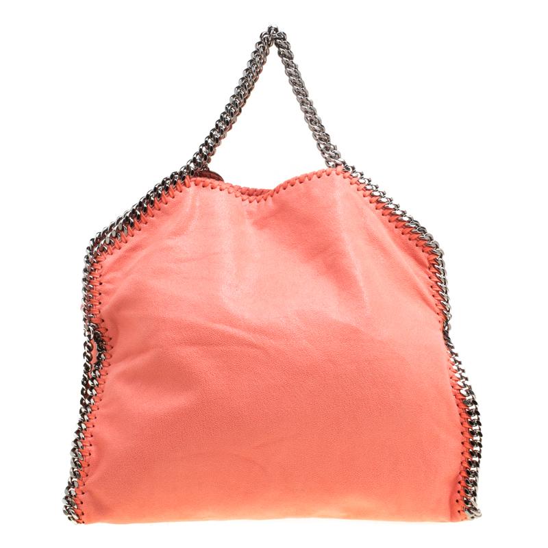 Stella McCartney is known for her chic designs and this Falabella tote perfectly embodies this trait. Crafted in Italy from coral faux leather with a fabric interior, this bag has a beautiful exterior and black tone chain details at its contours and