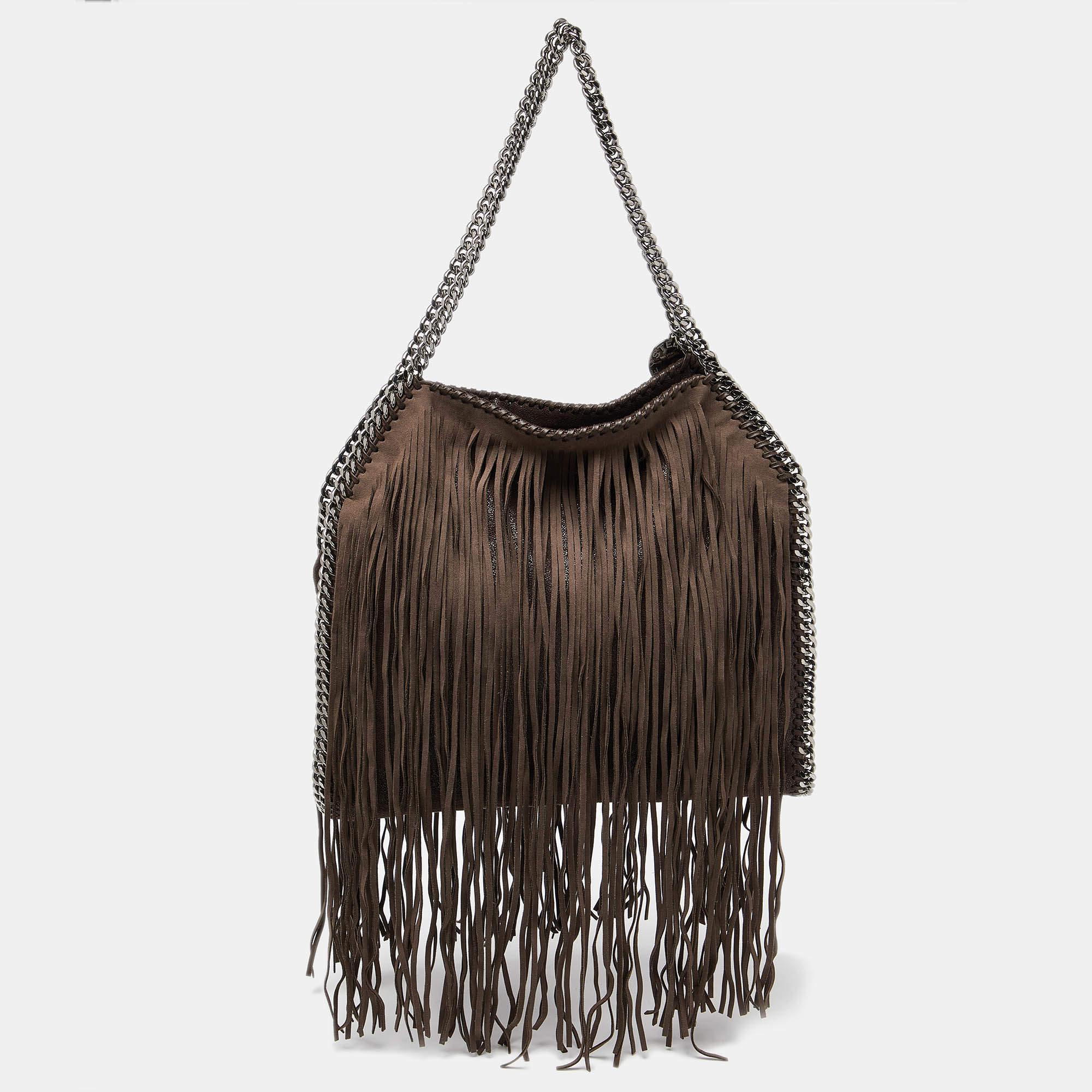 The chain whipstitch detailing beautifully outlines this Stella McCartney Falabella tote. Crafted from faux suede, it has been adorned with gun metal-tone accents, and it can be carried with dual chain handles. The fabric-lined interior of this bag