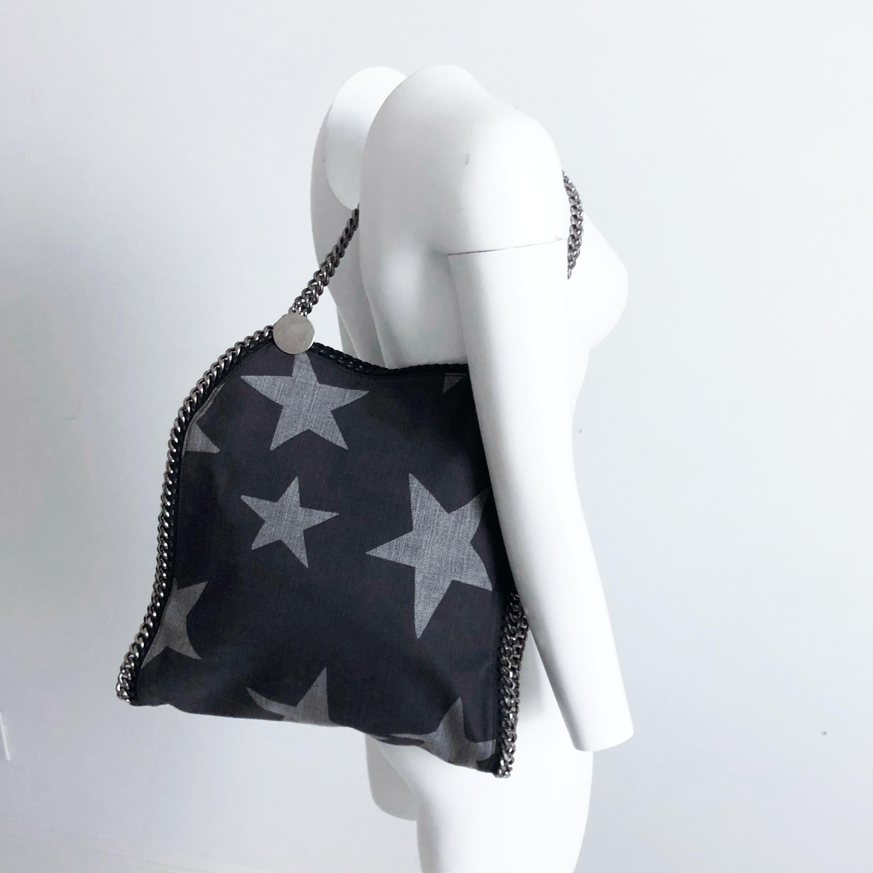 Authentic, preowned Stella McCartney Denim Star Small Falabella Tote. Made from dark washed denim with a decorative star printed pattern. It's bordered w/silver chain links that make a continuous chain shoulder straps. Magnetic closure/jacquard