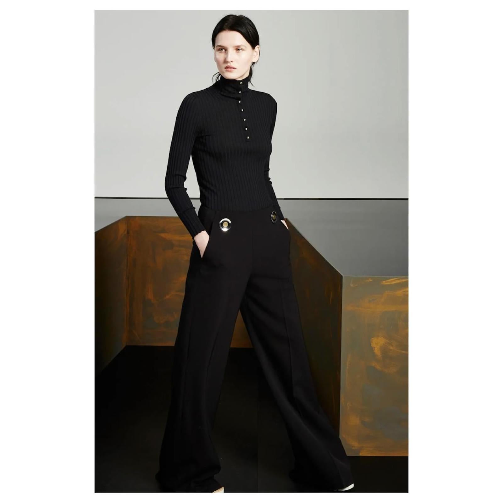 Le pantalon large Stella McCcrtney est à la fois chic et rétro. Acheté pour £895 et porté une fois. Confectionnée en laine noire épaisse, elle présente une coupe à jambes larges très fluide et est ornée de disques métalliques rétro à la taille. Ils