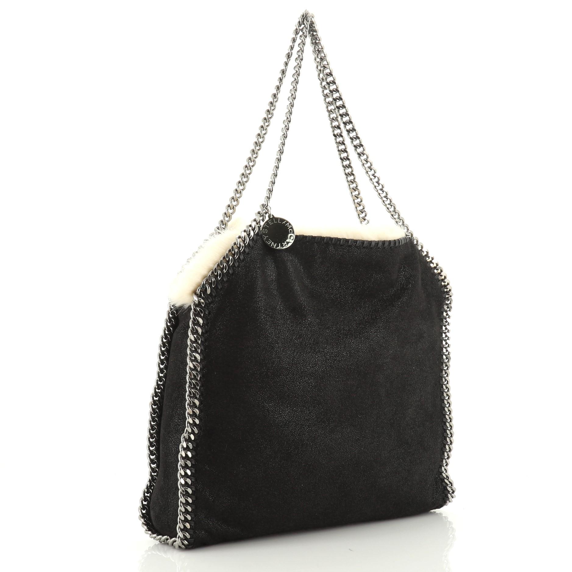 This Stella McCartney Falabella Reversible Tote Shaggy Deer and Faux Fur Small, crafted in black shaggy deer, features chain link strap and trim, whipstitched edges, and gunmetal-tone hardware. It opens to a neutral faux fur interior. 

Estimated