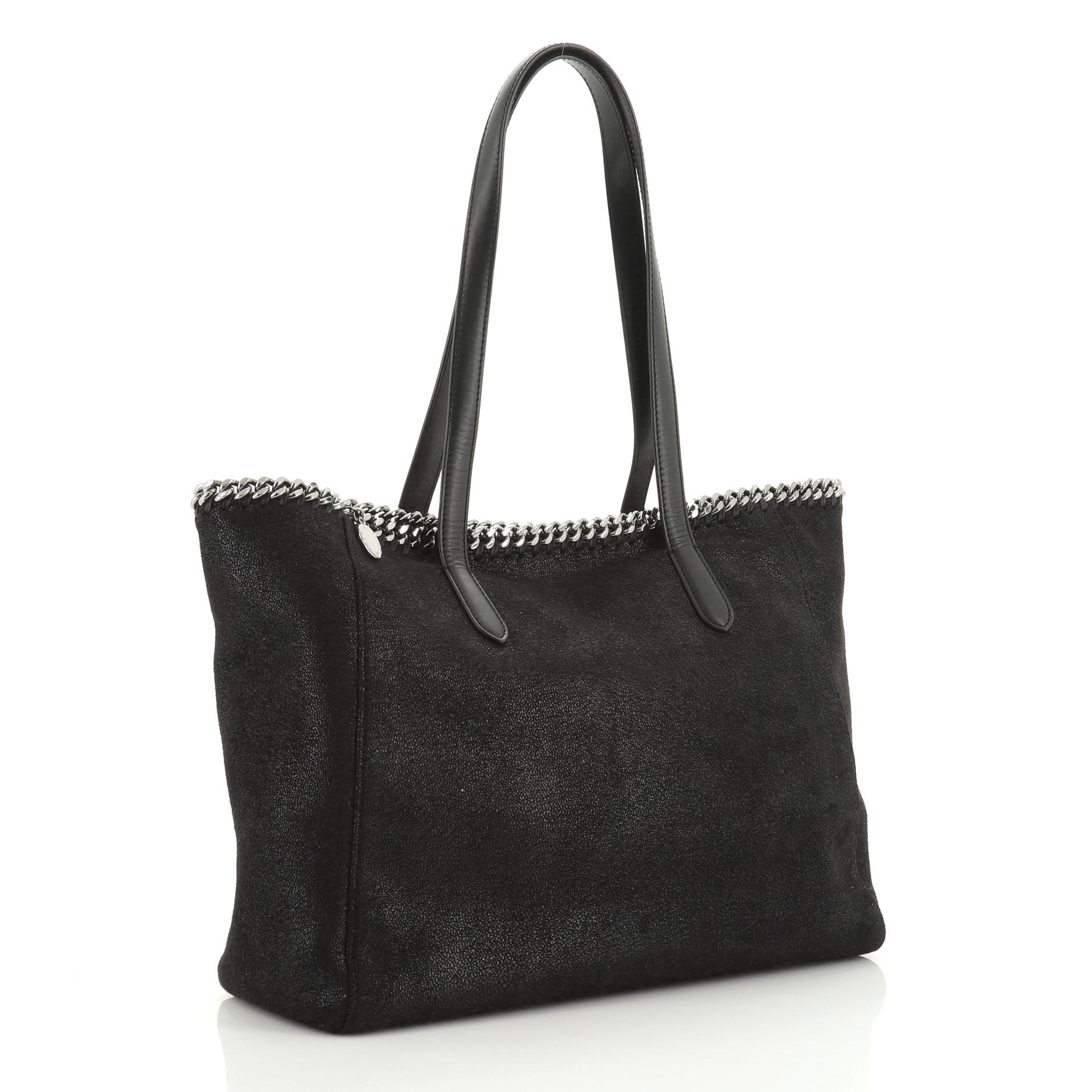 This Stella McCartney Falabella Shopper Tote Shaggy Deer East West, crafted in black fabric, features dual flat handles, chain trim and gunmetal-tone hardware. It opens to a pink fabric interior. 

Estimated Retail Price: $985
Condition: Excellent.