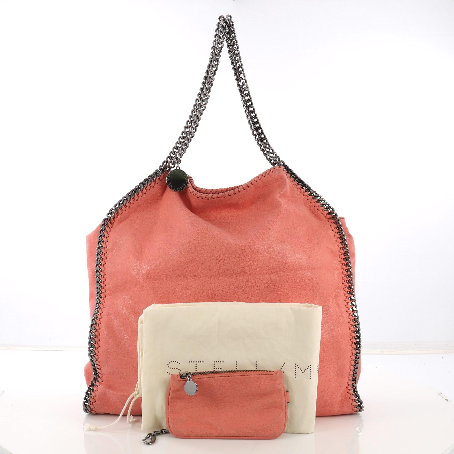 This Stella McCartney Falabella Tote Shaggy Deer Large, crafted from pink shaggy deer, features chain link handles and trim, whipstitched edges, hanging logo disc, and gunmetal-tone hardware. Its magnetic snap closure opens to a pink fabric interior