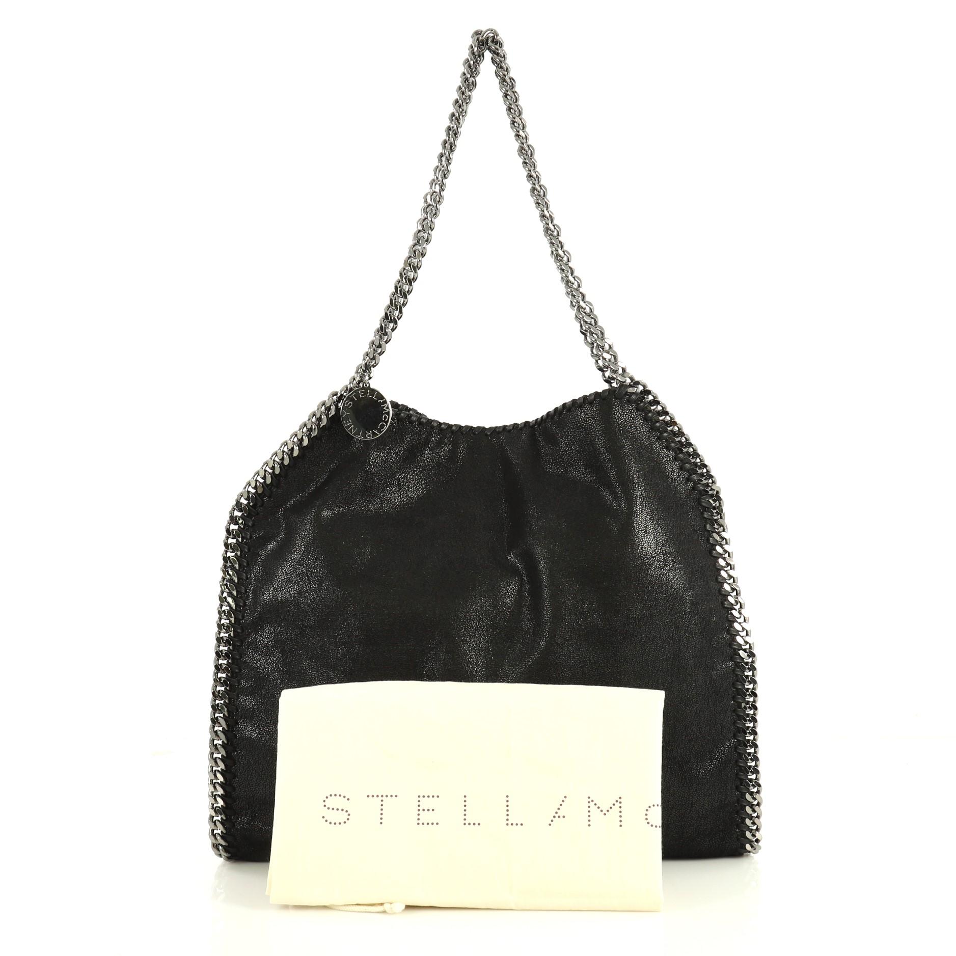 This Stella McCartney Falabella Tote Shaggy Deer Small, crafted from black shaggy deer, features chain link handles and trim, whipstitched edges, hanging logo disc, and gunmetal-tone hardware. Its magnetic snap closure opens to a pink fabric