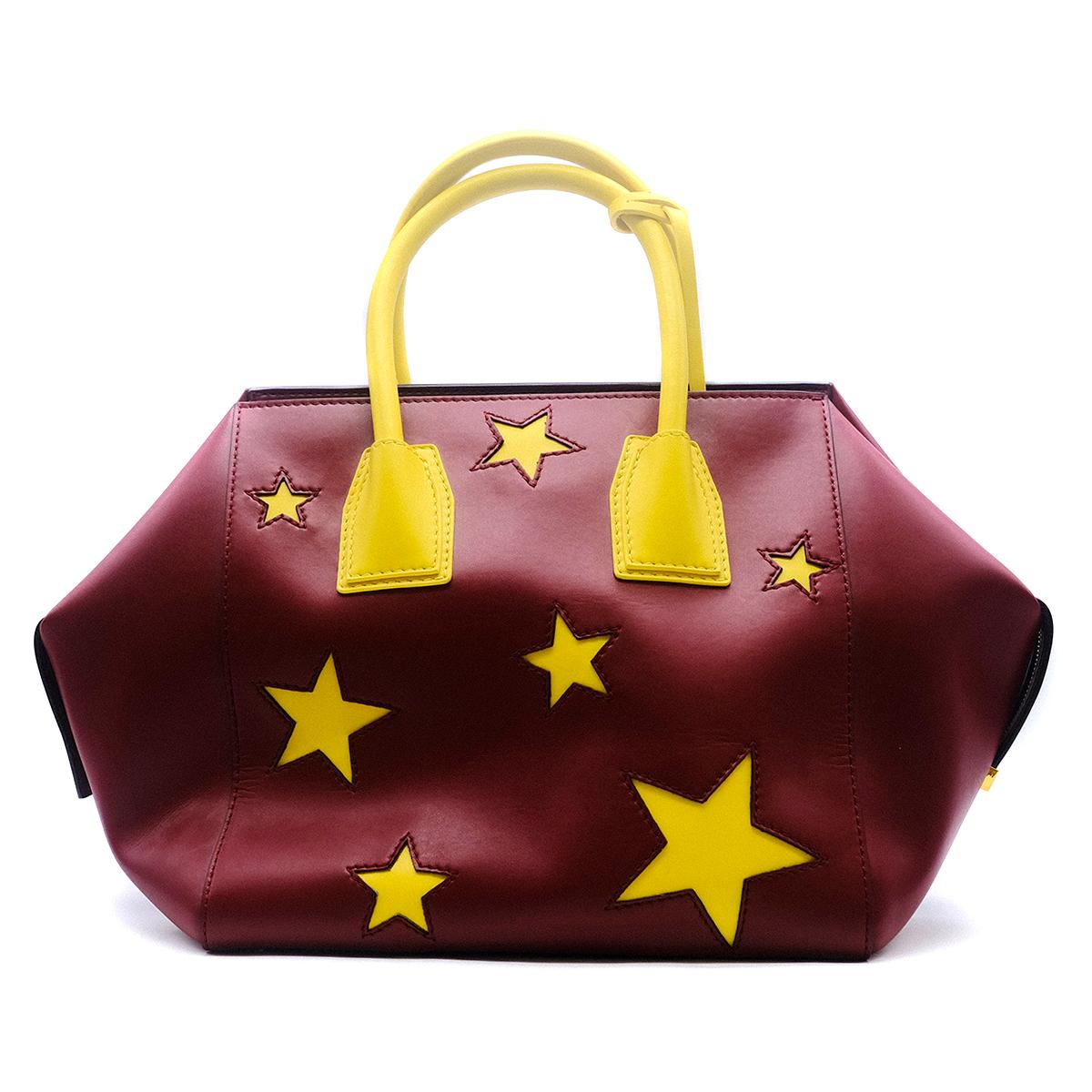 Stella McCartney Faux-Leather Stars Embossed Tote Bag

- Red & yellow tote bag 
- Contrasting star cutouts 
- Rolled yellow tote handles
- Gold-tone hardware zip fastening
- Bag charm with a gold plated Stella McCartney logo
- Interior pocket
- This