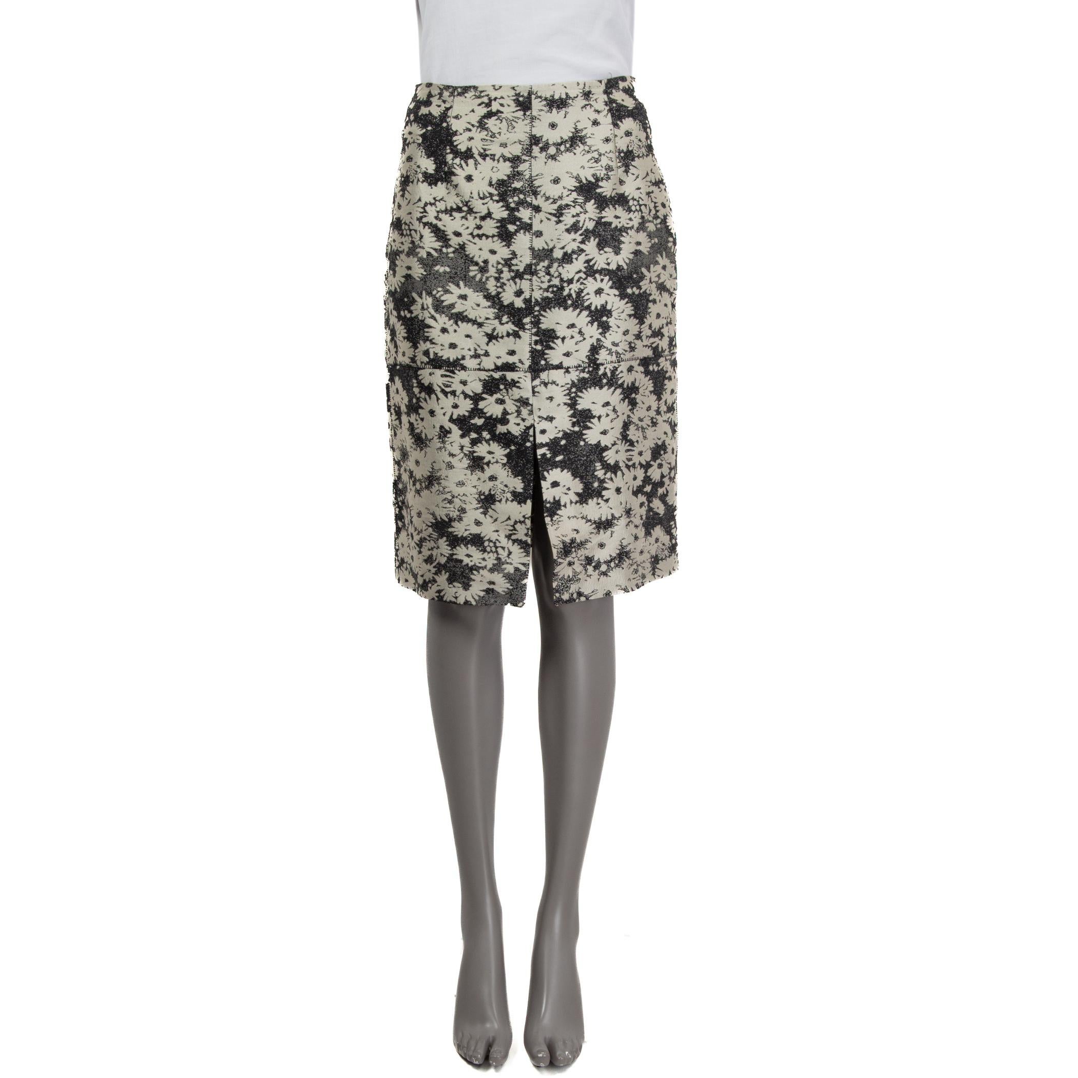 100% authentic Stella McCartney jacquard floral knee-length skirt in black, gray and silver cotton (60%), polyester (32%) and silk (8%). Features a slit on the front. Opens with a zipper and a hook at the back. Unlined. Has some faint stains of