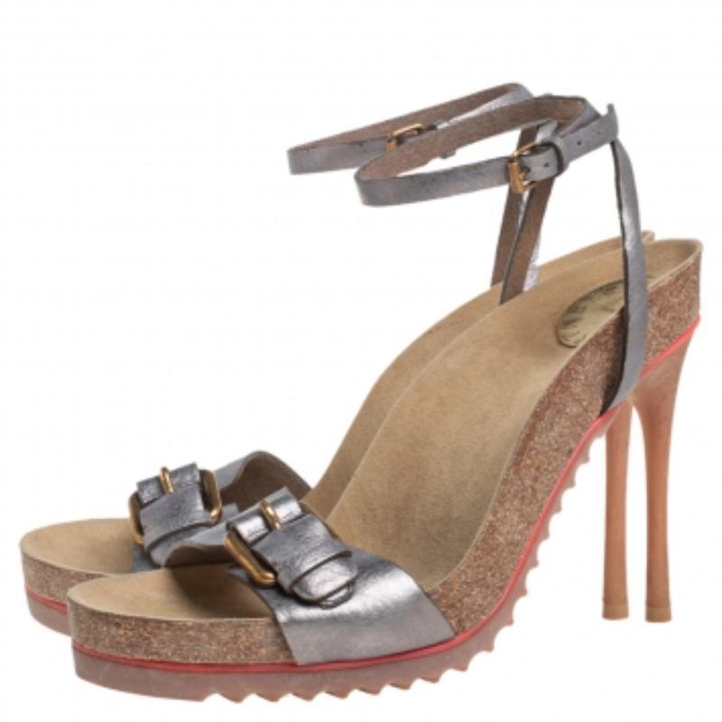 Perfect to flaunt, this pair of sandals by Stella McCartney is simply amazing! The metallic grey sandals have been crafted from faux leather and designed with open toes, single vamp straps with buckle details, and slender ankle straps. They are