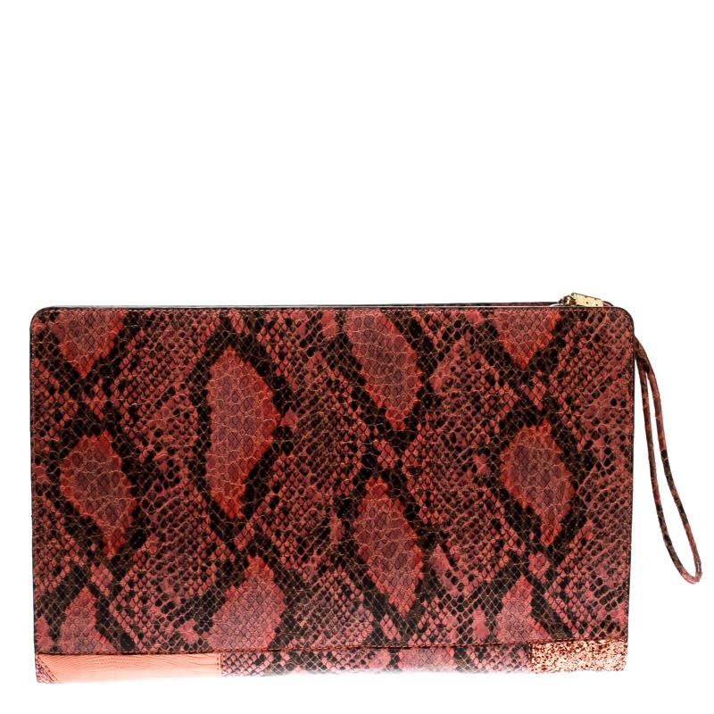A stunning creation, this Stella McCartney clutch is a must have! Its faux leather exterior is given an exotic look with a patchwork design using different materials and glitter. Its top zip closure is coupled with a wristlet and includes gold-tone