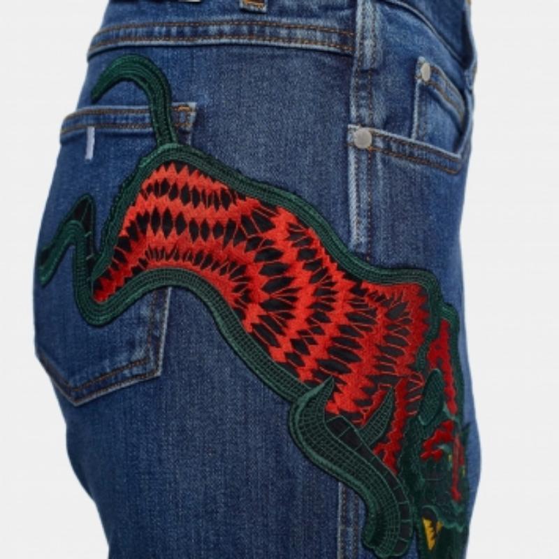 Ce jean élégant provient de la maison Stella McCartney. Confectionné en denim, ce jean se décline dans une teinte classique de bleu marine. L'extérieur est également orné d'une broderie de chat sauvage et est doté de poches et d'une coupe fuselée.