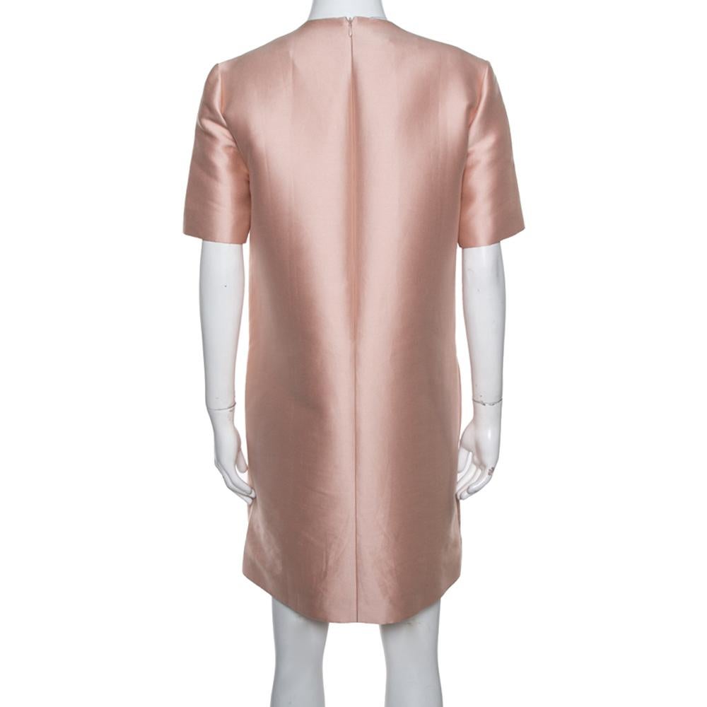 Stella McCartney's elegant and feminine approach is evident from this peach-hued dress. It features exquisite floral embroidery that twines across a chic A-line silhouette. The shift dress is complete with a round neckline, short sleeves, and a rear