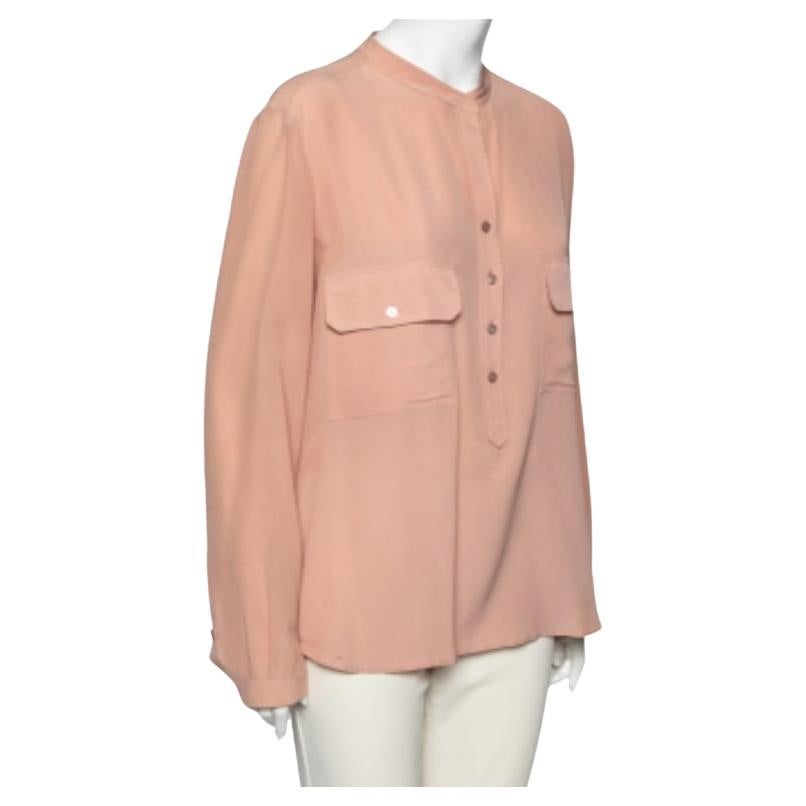 Añade un toque chic-femenino a tu atuendo con esta preciosa blusa de la Casa de Stella McCartney. Está diseñado con tejido de seda melocotón, que se realza con detalles de bolsillos en la parte delantera. Dispone de cierres abotonados y dos