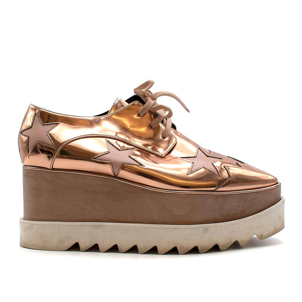 Reach for the stars in these platform starry Elyse shoes from Stella McCartney. Crafted from faux leather, these gold-tone shoes with cut-out stars are truly stella(r). Featuring a square toe, a lace-up front fastening, a branded insole, a low wedge