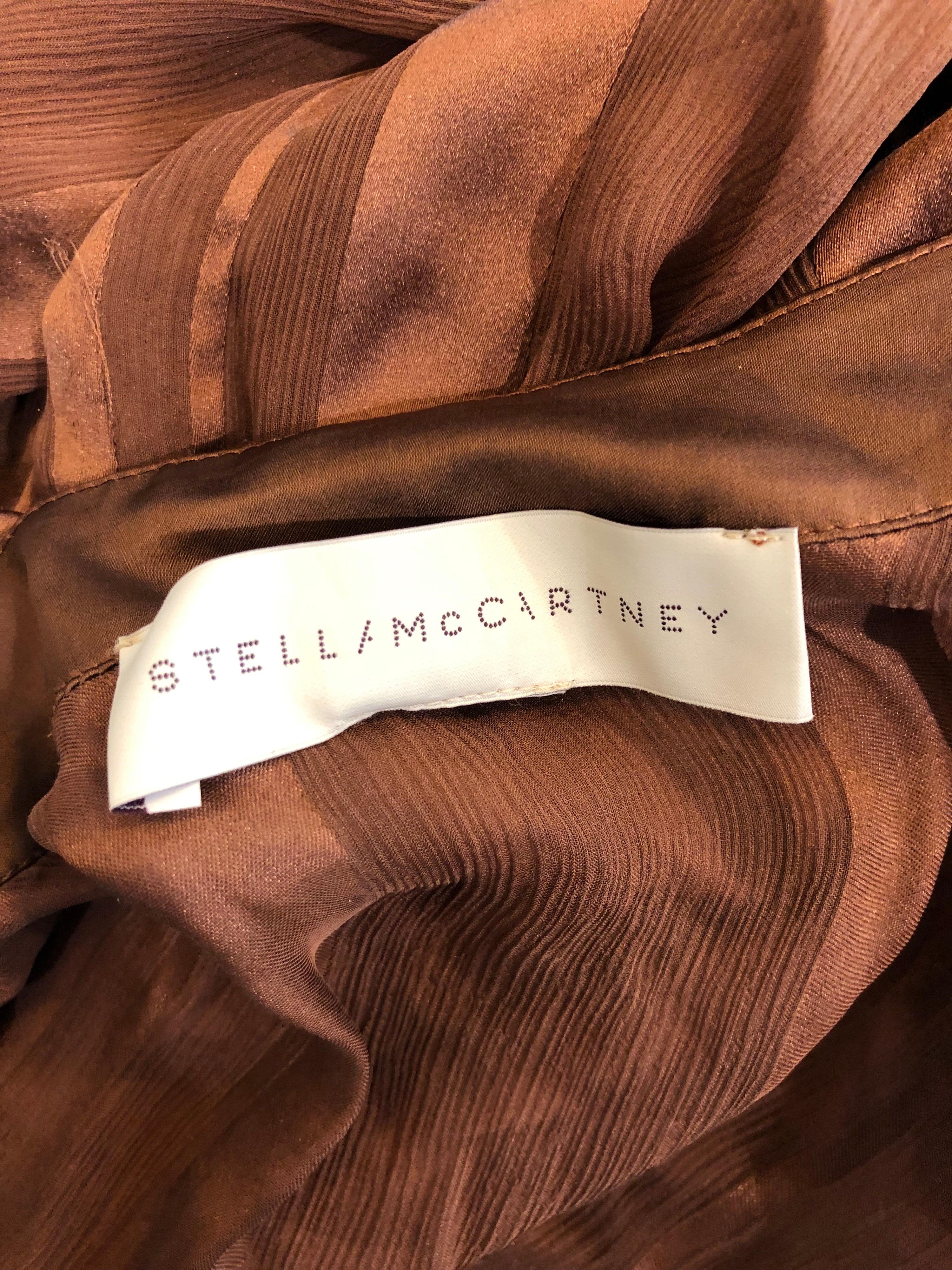 Undeniably chic STELLA MCCARTNEY rust brown colored silk chiffon semi sheer long sleeve blouse! A unique and stylish take on a typical blouse. Perfect color matches anything, and is a great pop against black trousers / skirt. Buttons up the upper