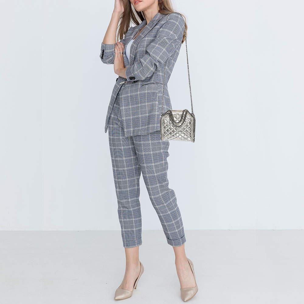 The chain whipstitch detailing beautifully outlines this Stella McCartney Falabella bag. Crafted from faux leather it has been adorned with silver tone accents and it can be carried with dual chain handles. The fabric lined interior can safely store