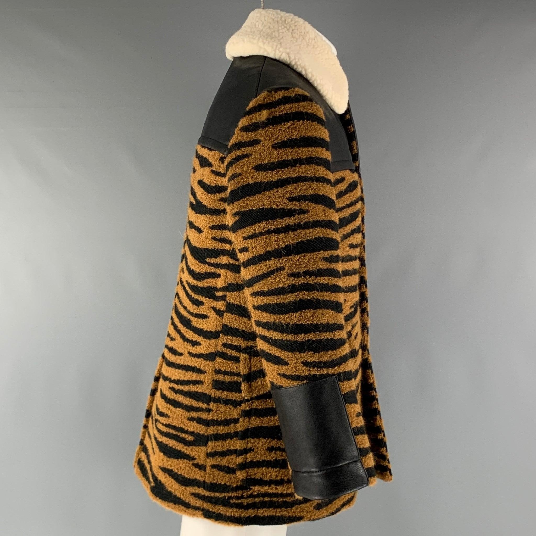 STELLA McCARTNEY coat comes in a black & tan animal print polyester heavy material featuring a black quilted lining, sherpa fleece cream collar, flap pockets, and a button up closure. Made in
Italy.Very Good Pre-Owned Condition. Minor signs of Wear.