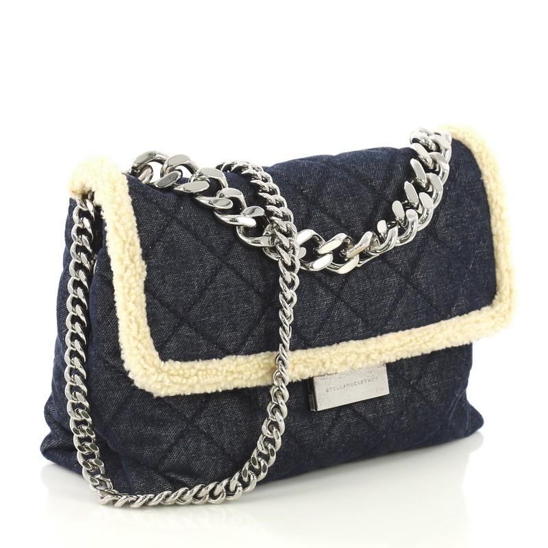 This Stella McCartney Soft Beckett Shoulder Bag Quilted Denim with Faux Shearling Small, crafted from blue quilted denim with faux shearling, features curb chain top handle, frontal flap, and silver-tone hardware. Its clasp closure opens to a beige