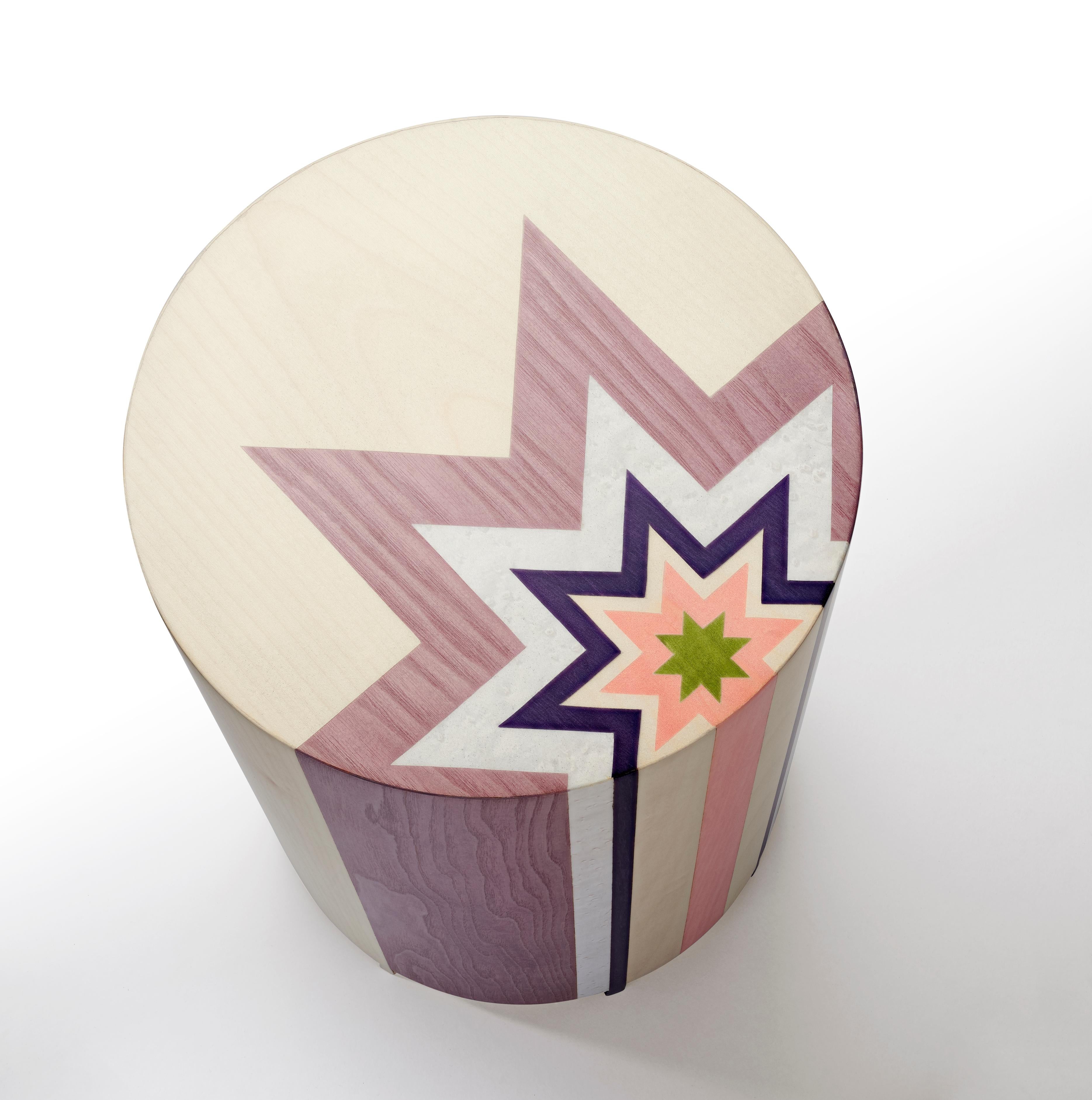 The rebirth of marquetry celebrated in a pop art inspired piece of furniture!
This circular side table is a wood construction with 6 legs. The table is entirely covered with marquetry in coloured sycomore, tay, bolivar, pama and bird’s eye maple