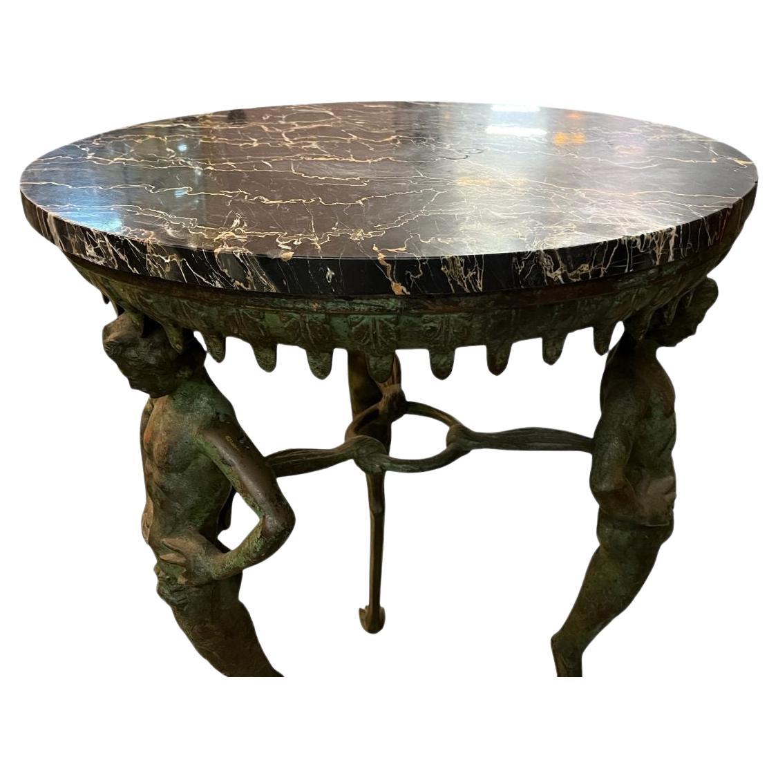 Remarkable Grand Tour Bronze and Marble table featuring three Satyrs holding up a beautiful bronze motif circle with a marble top. A very unique and rare find from the period. Wonderful patina to the bronze a few small chips to the marble. No